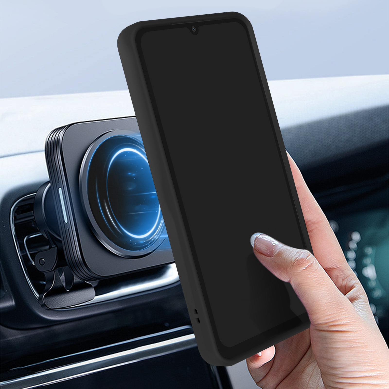 Un telefono nero attaccato a un supporto magnetico per auto, tenuto da una mano all'interno.