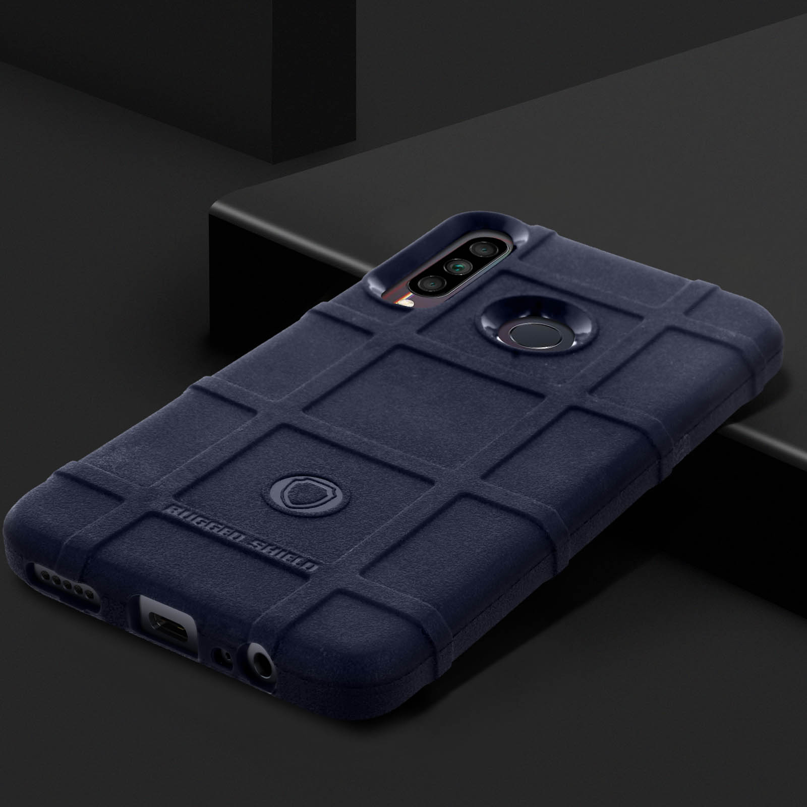 Custodia blu scuro, motivo a griglia, tre fori fotocamera, design robusto, su superficie scura.