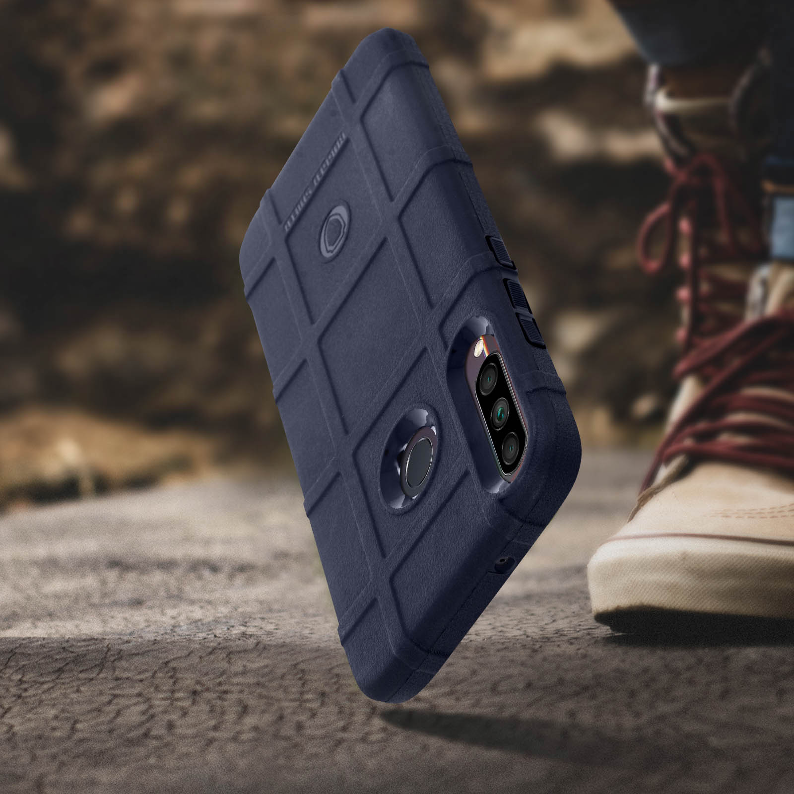 Custodia per telefono blu scuro con design strutturato, vicino alle gambe e alle scarpe.