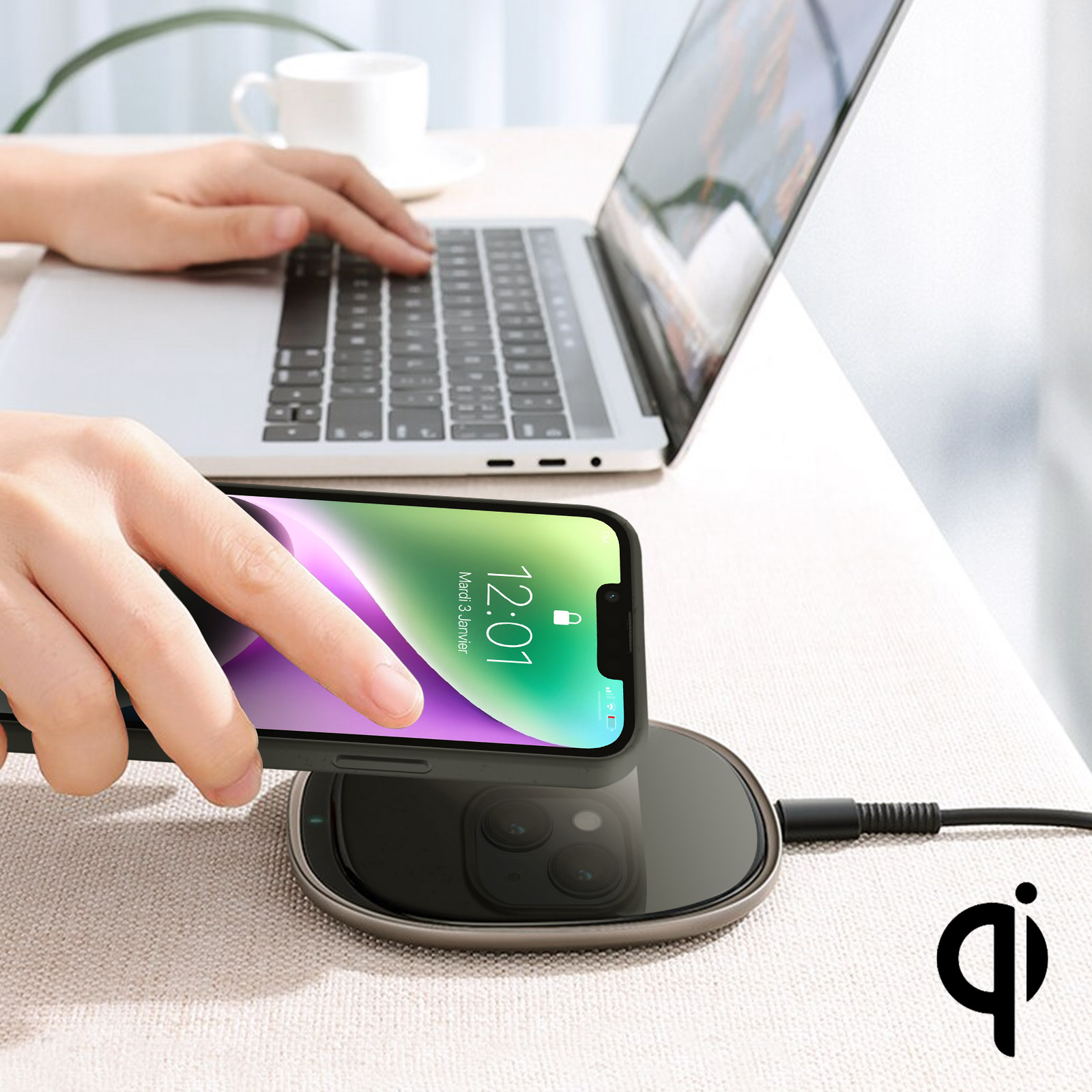 Mani di una persona che lavora con un laptop e un telefono su un caricatore wireless.