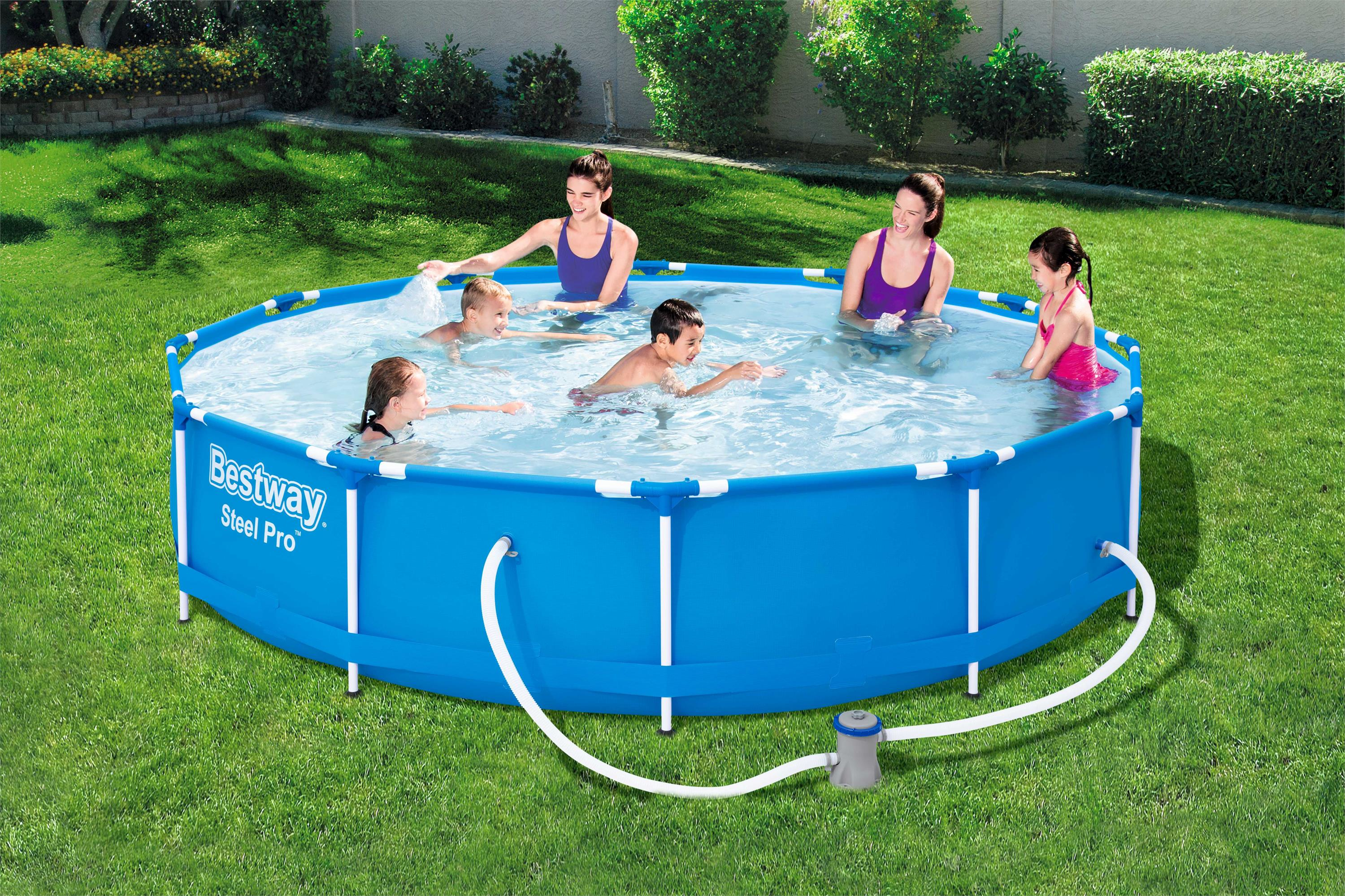 Eine Gruppe von Menschen in einem blauen oberirdischen Pool auf einem grünen Rasen.