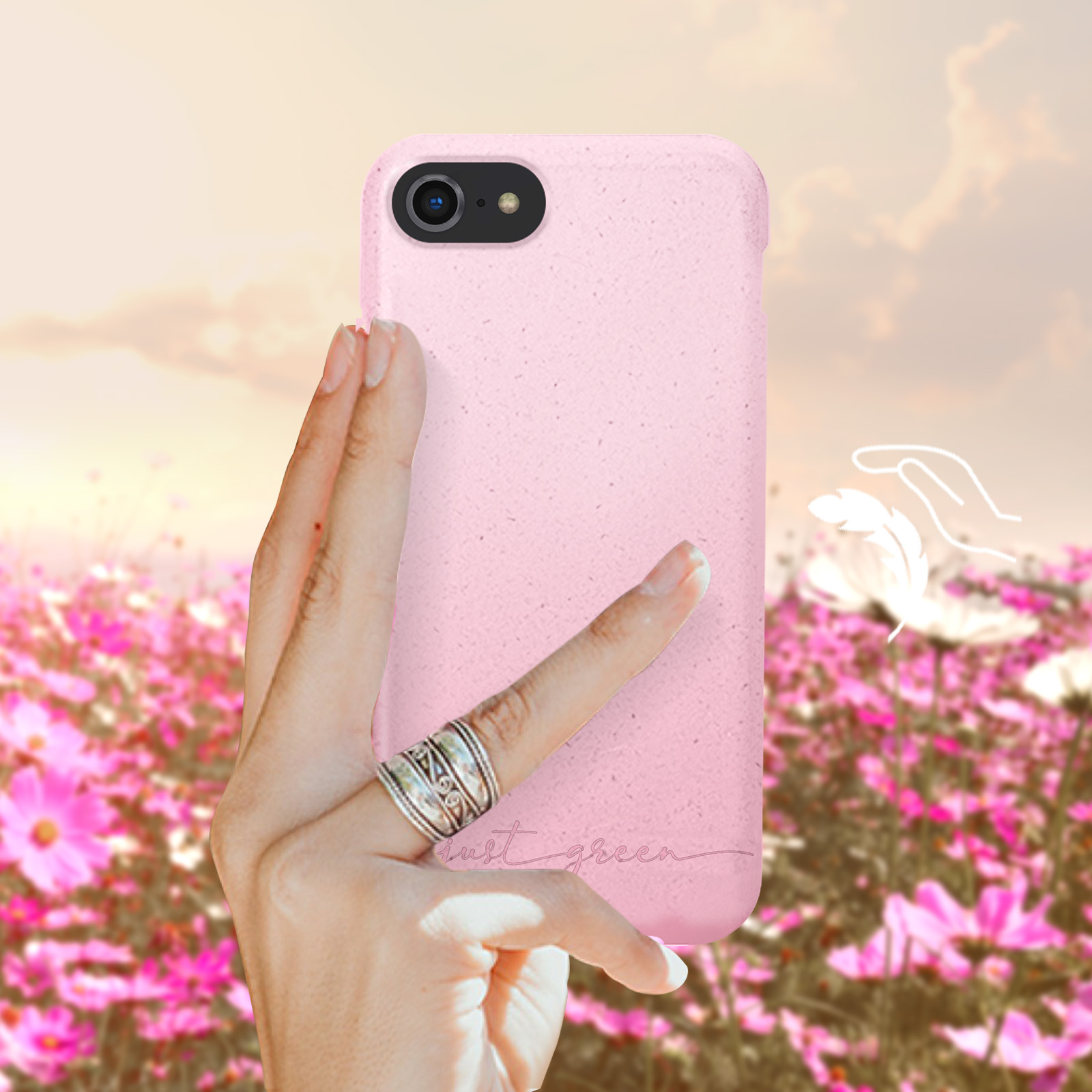 Rosa Handyhülle, Hand hält sie mit Ring. Blumenfeld im Hintergrund, Himmel mit Wolken.