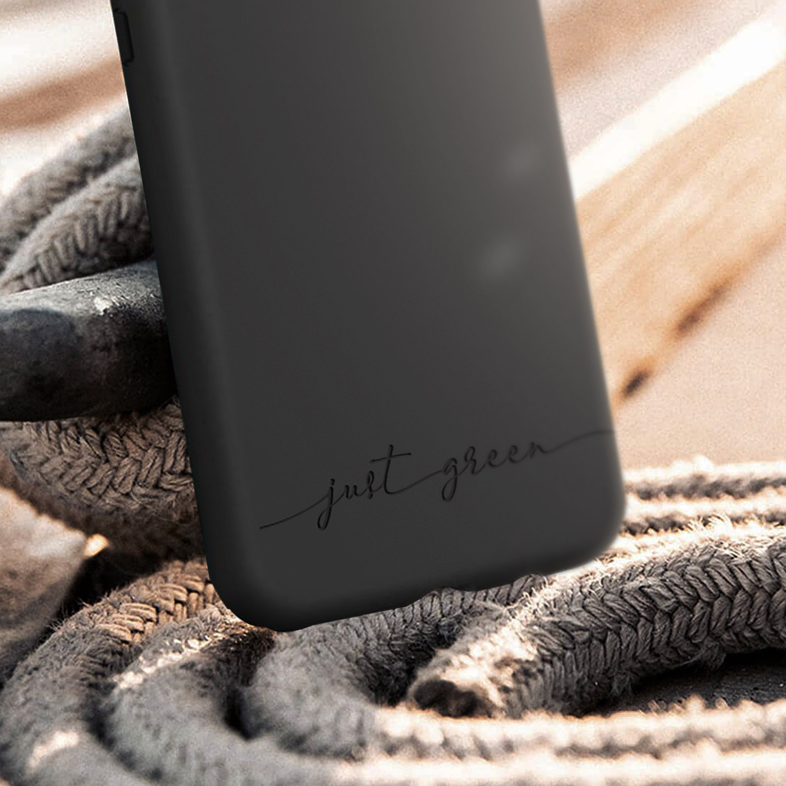 Custodia nera con testo 'just green', su una superficie di legno.