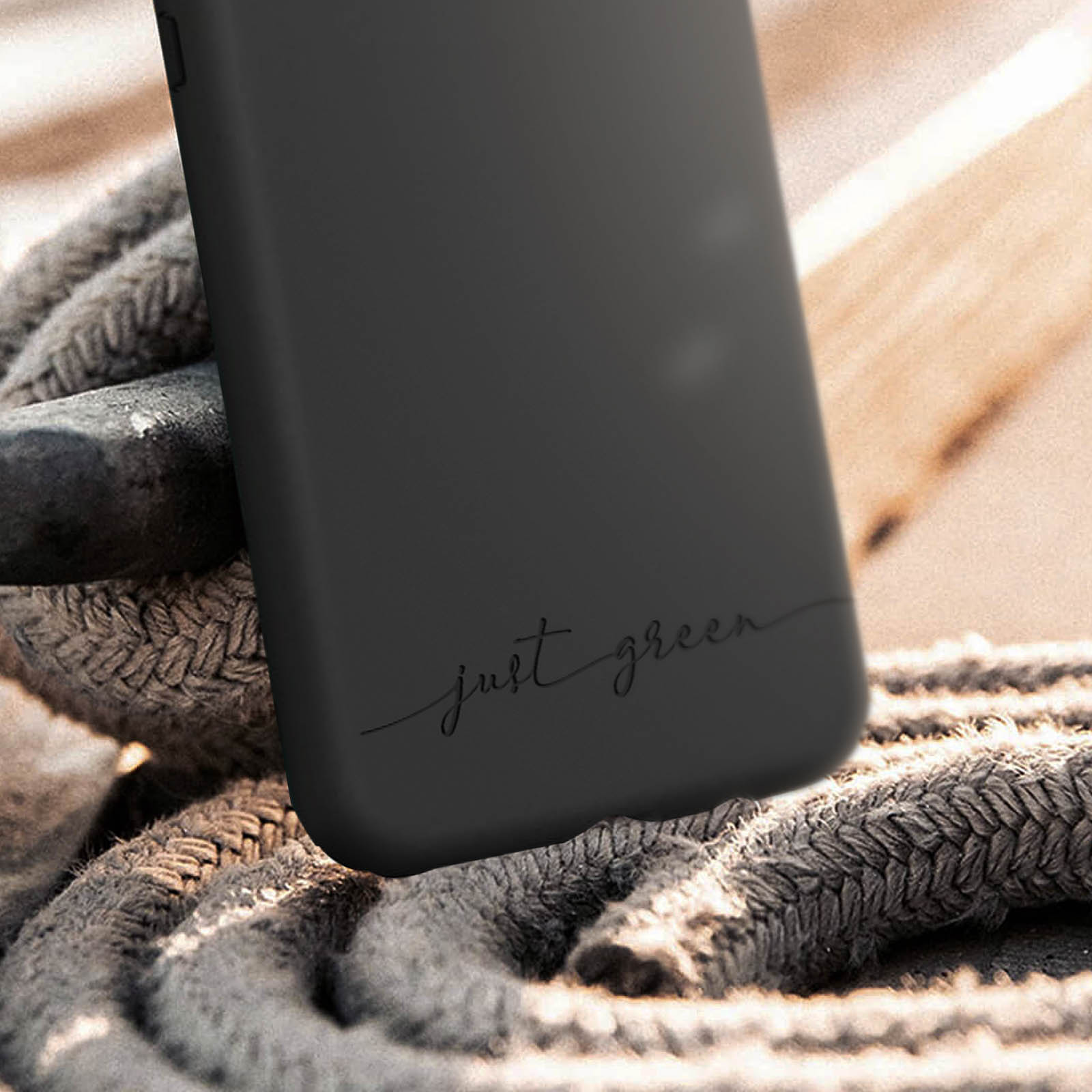 Custodia nera con scritta 'just green'. La custodia è su una superficie di legno.