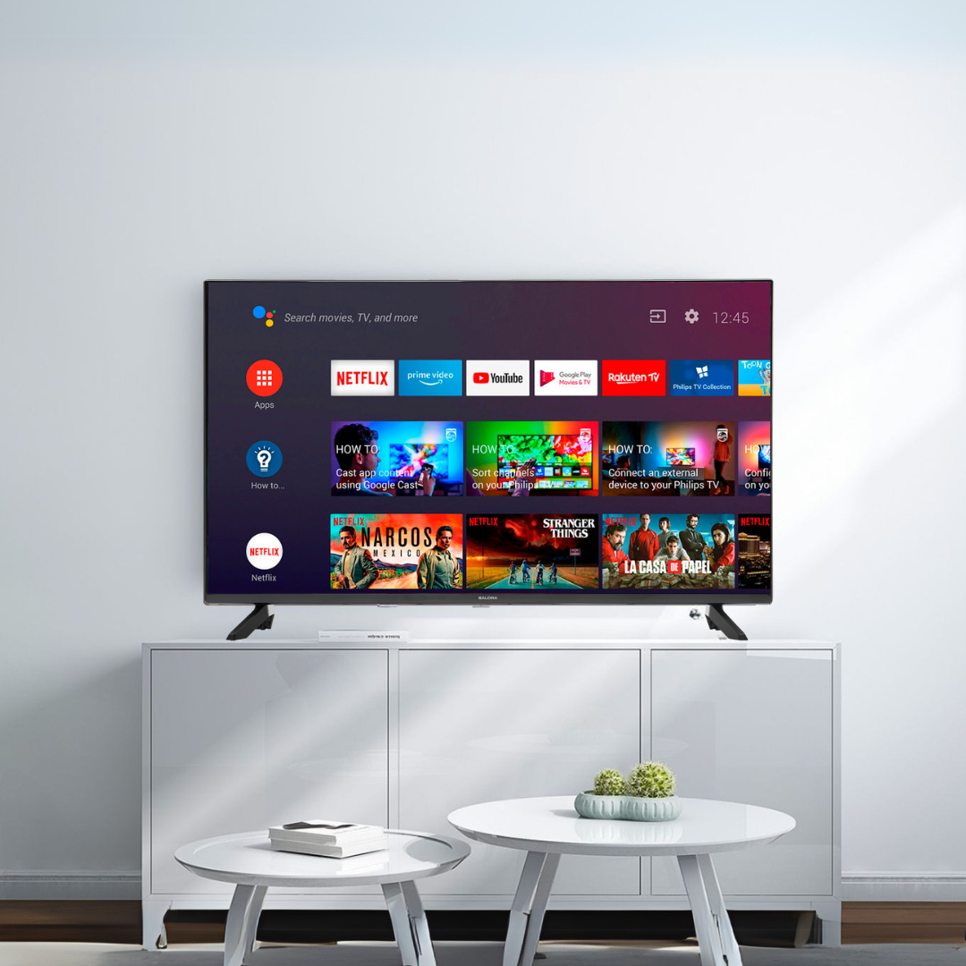 Téléviseur sur meuble blanc avec applications de streaming. Deux tables blanches devant.