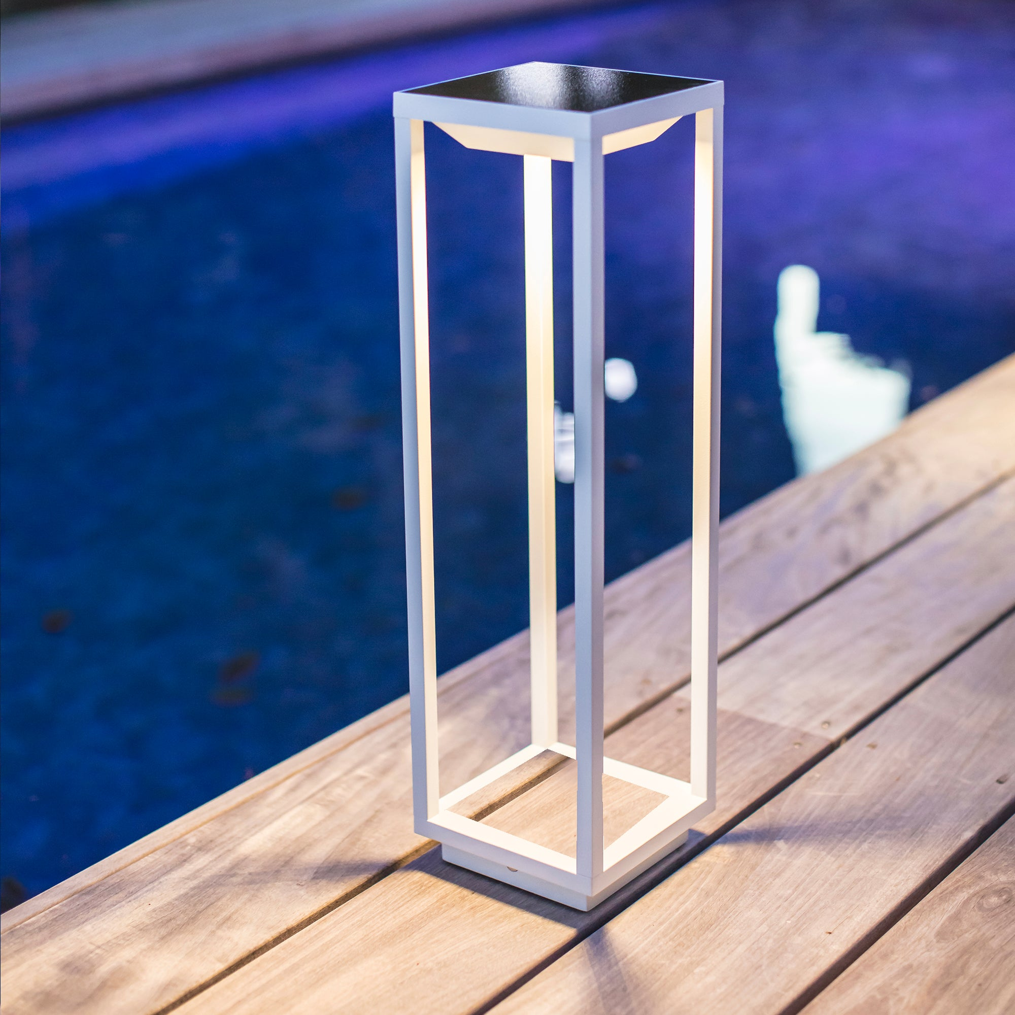 Weiße Außenlampe auf Holzoberfläche. Blauer Wasserhintergrund.