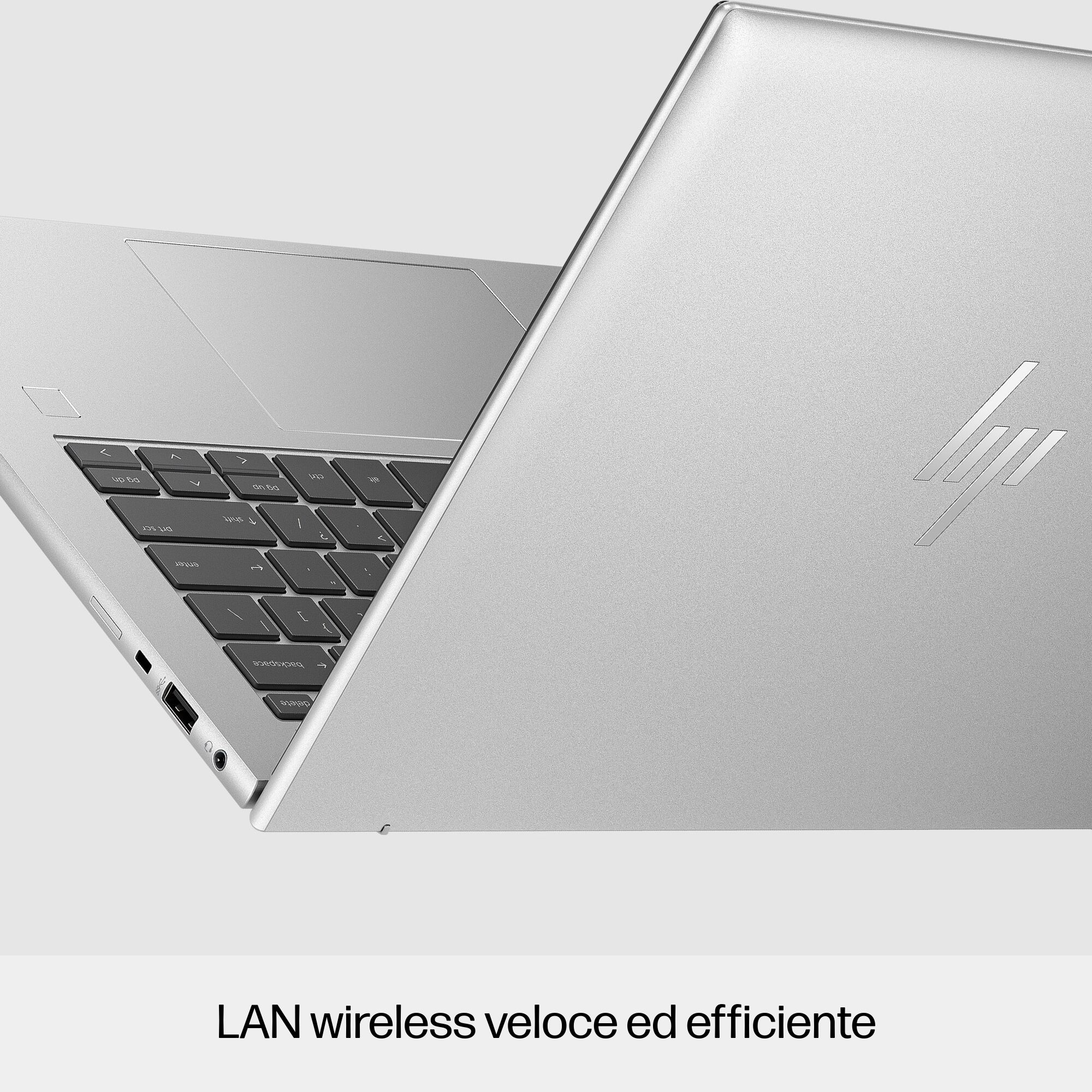 Laptop argentato, parzialmente aperto, tastiera visibile, con il logo HP sul retro.