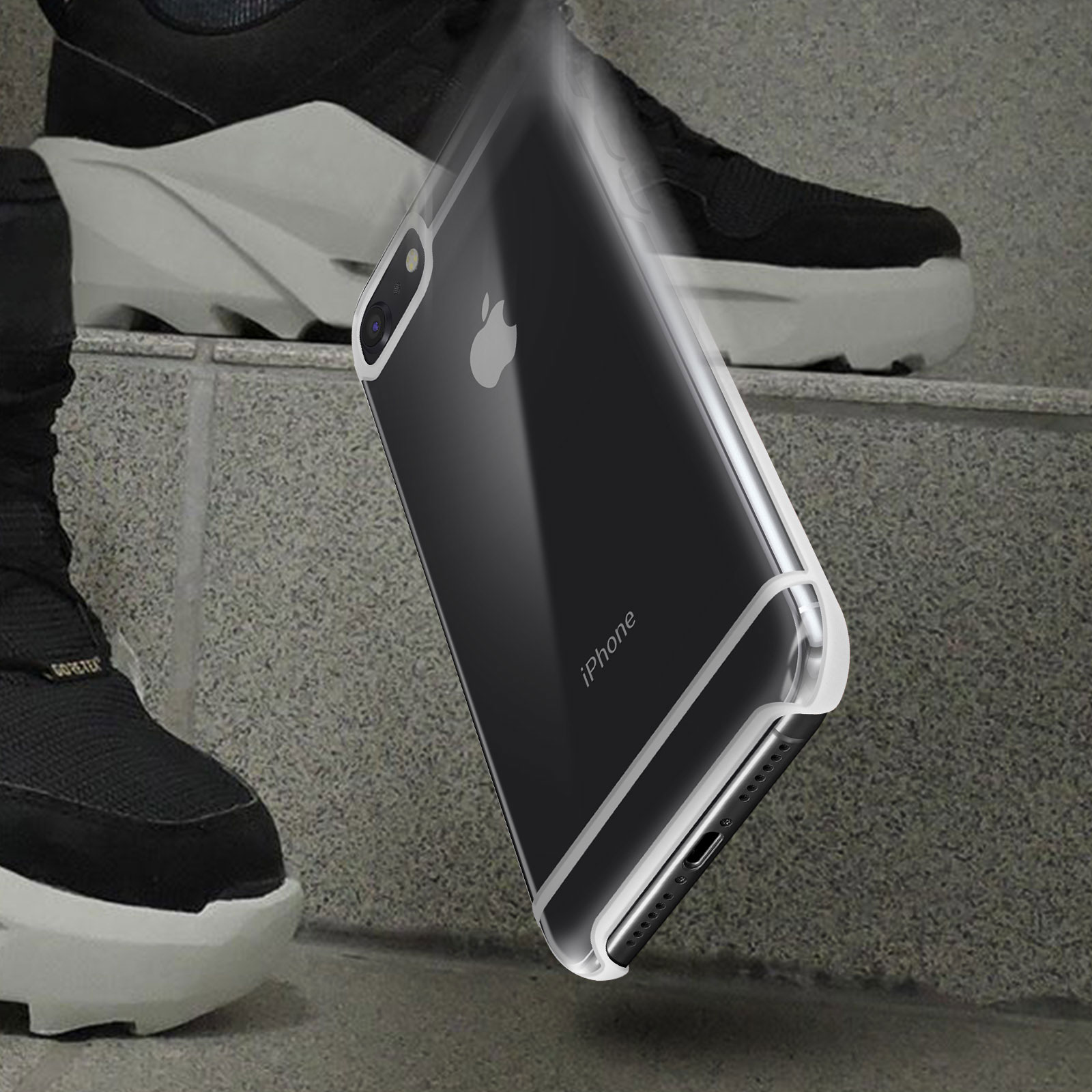 Una custodia trasparente per iPhone riflette la luce. Sneakers nere sullo sfondo. Il telefono è angolato.