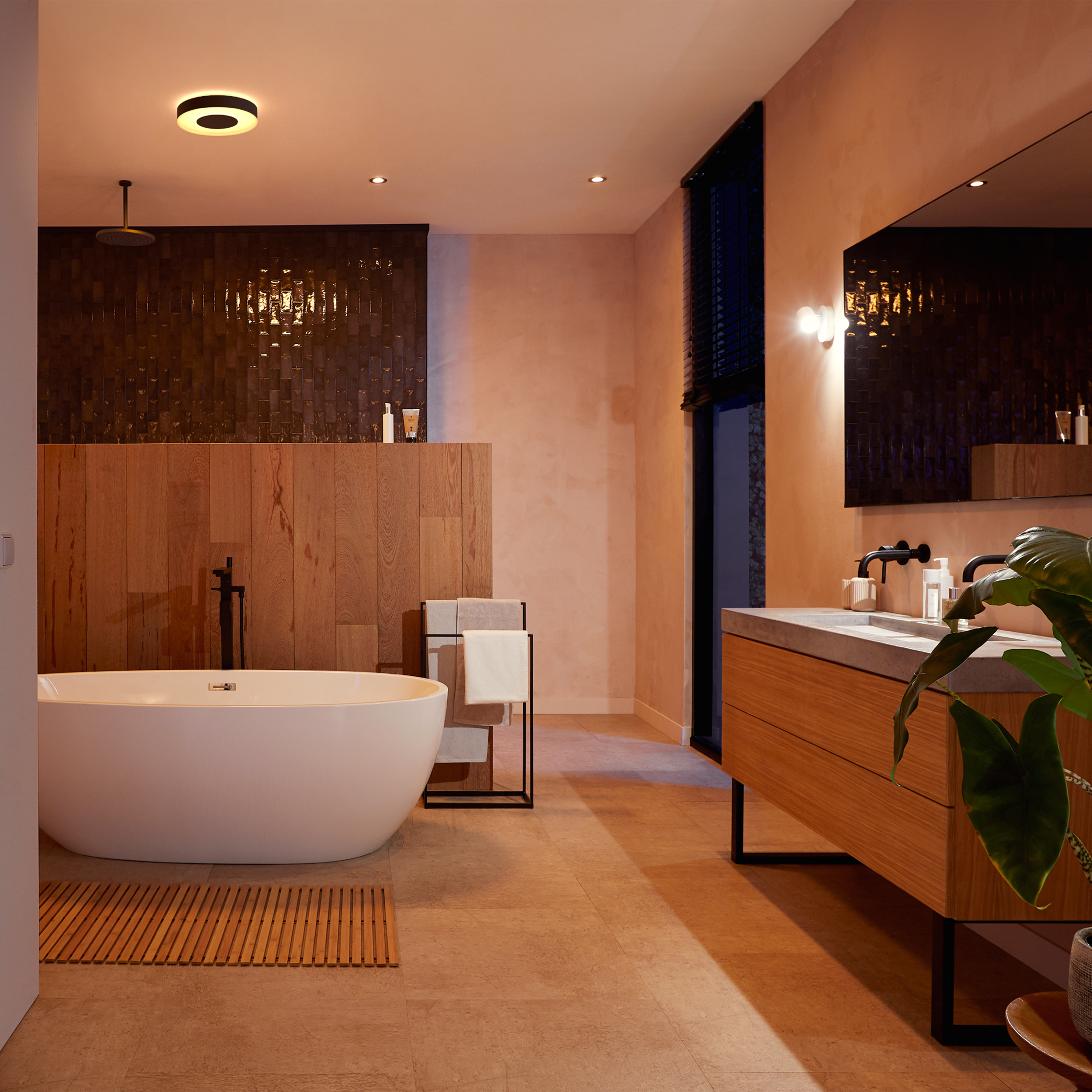 Łazienka z wanną, umywalką i lustrem. Drewniane panele, białe ściany i ciepłe oświetlenie.