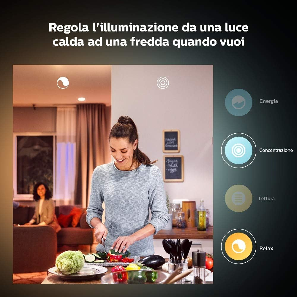 Woman in kitchen cutting vegetables. Kitchen with lights and cooking items on the counter.