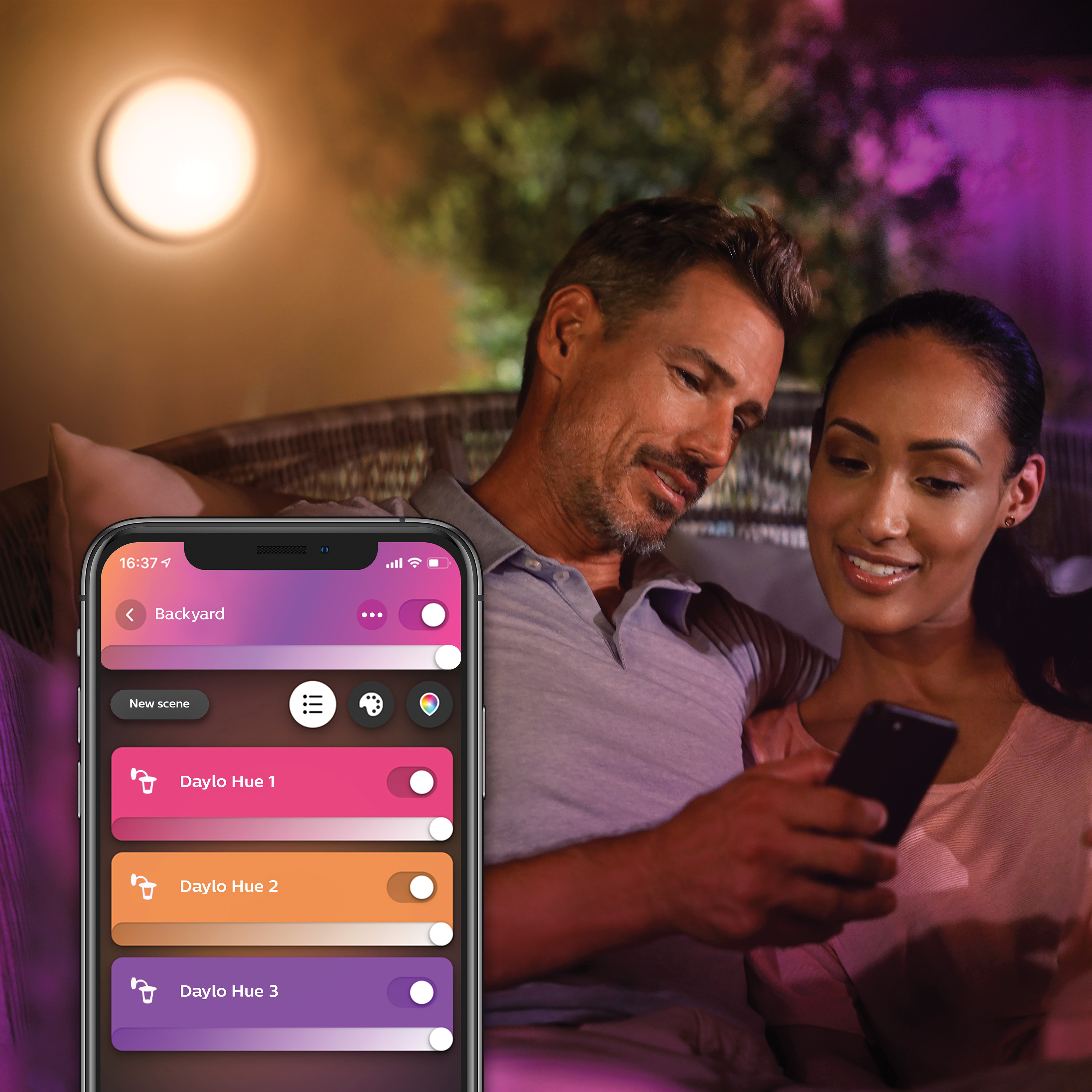 Een stel dat een slimme thuis-app op een telefoon gebruikt om lichten te bedienen.