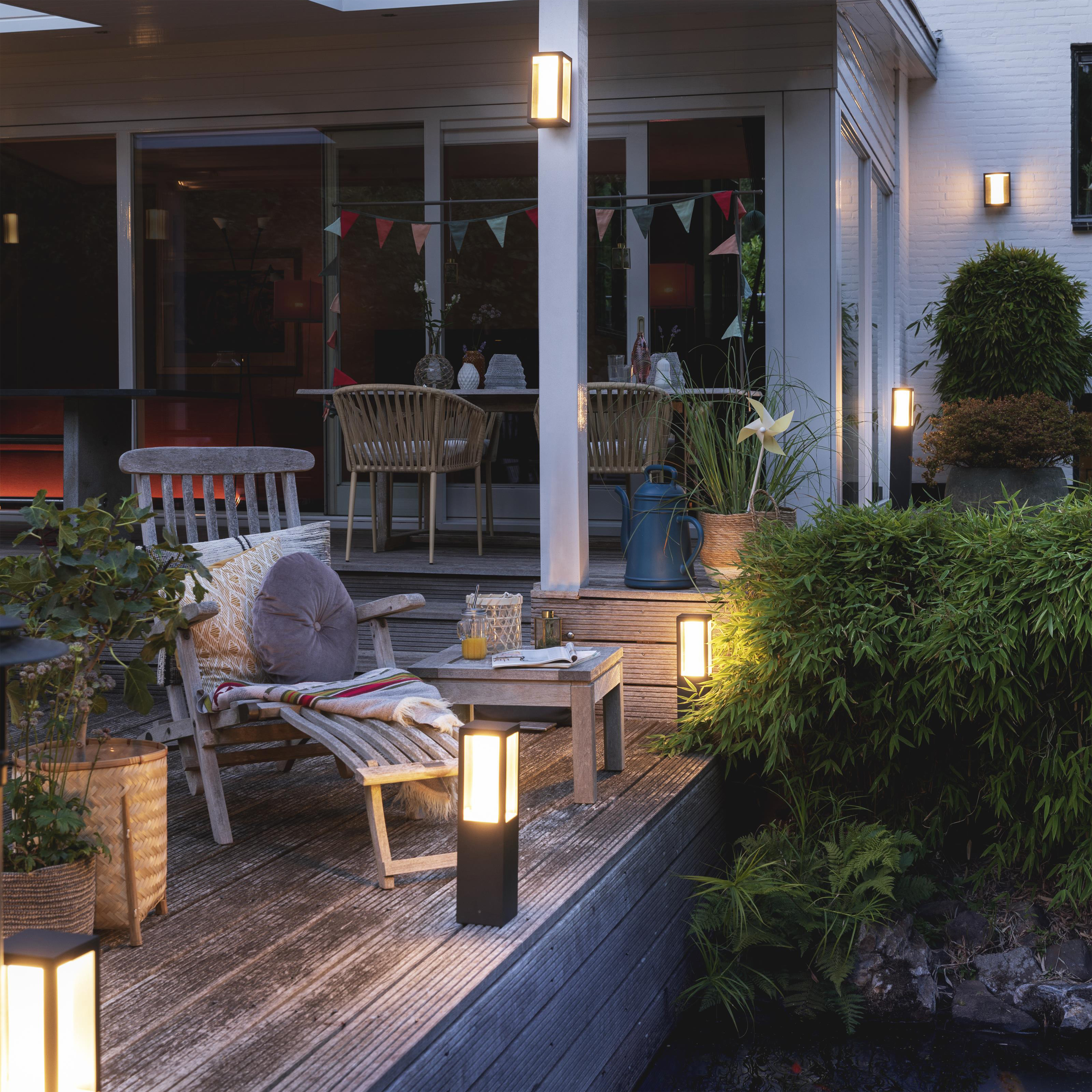 Scena na zewnątrz ze światłami, krzesłem i roślinami.