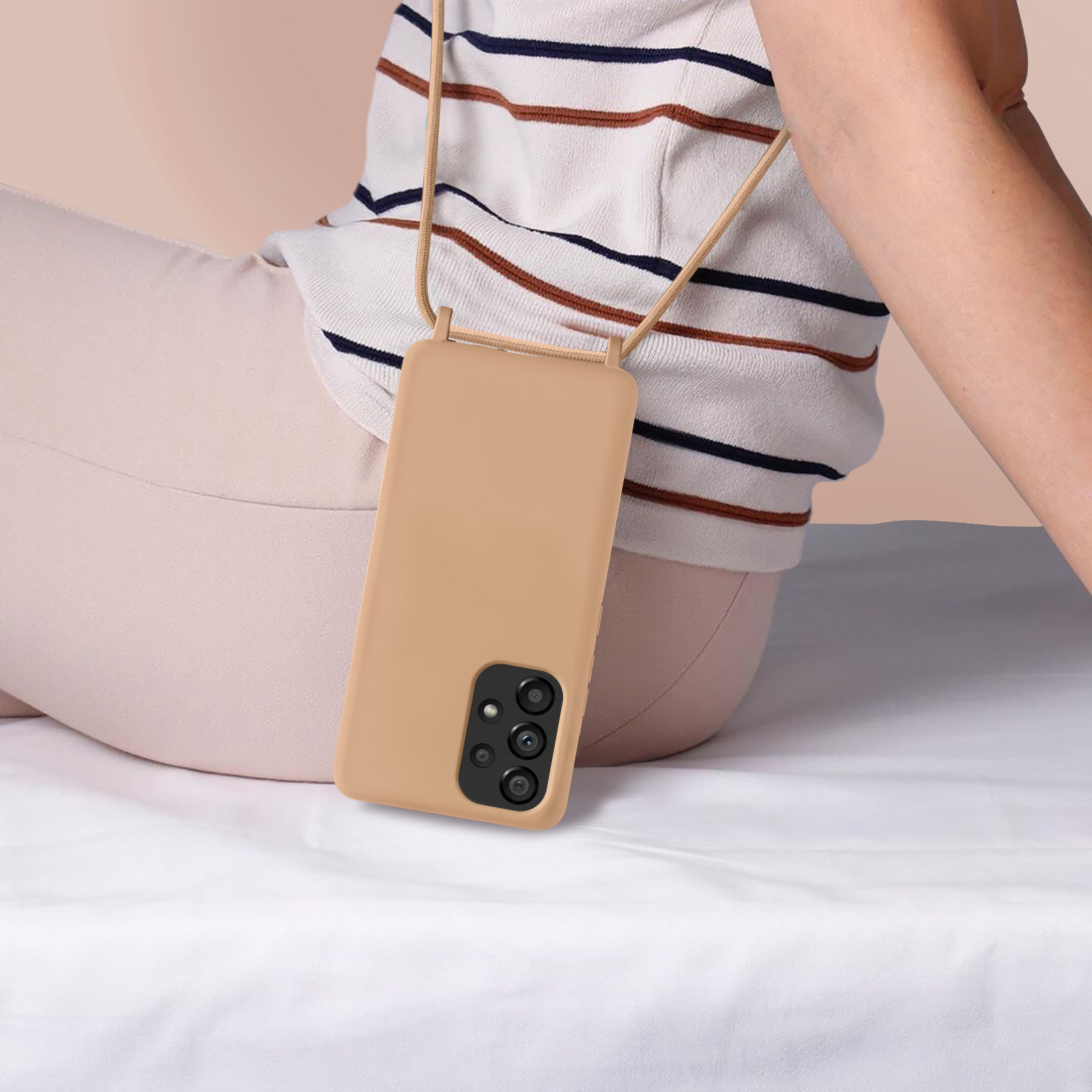 Une coque de téléphone beige avec un cordon, sur les genoux d'une personne.