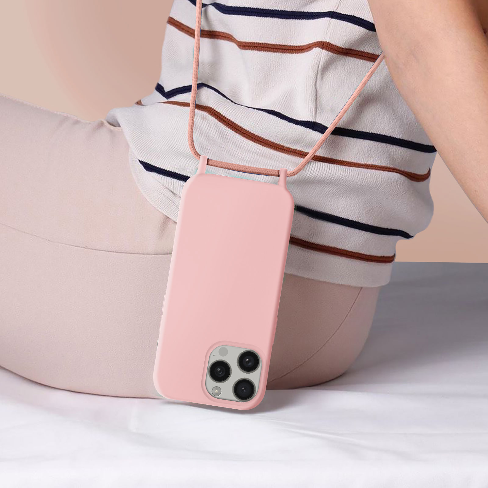 Una custodia rosa per telefono con un cordino abbinato. Il telefono è indossato da una persona.