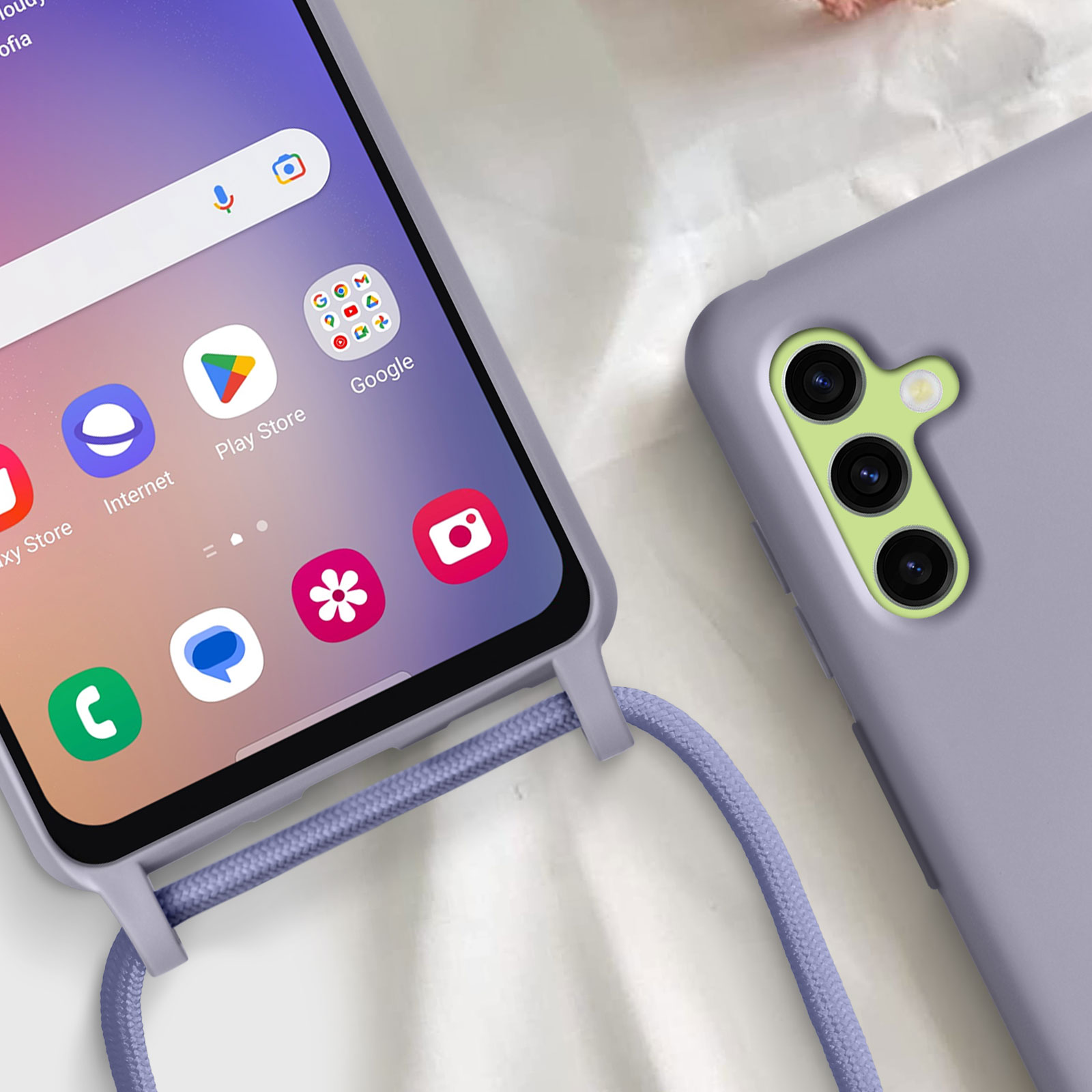 Telefono viola con custodia e cordino. Lo schermo mostra le icone delle app. Primo piano.
