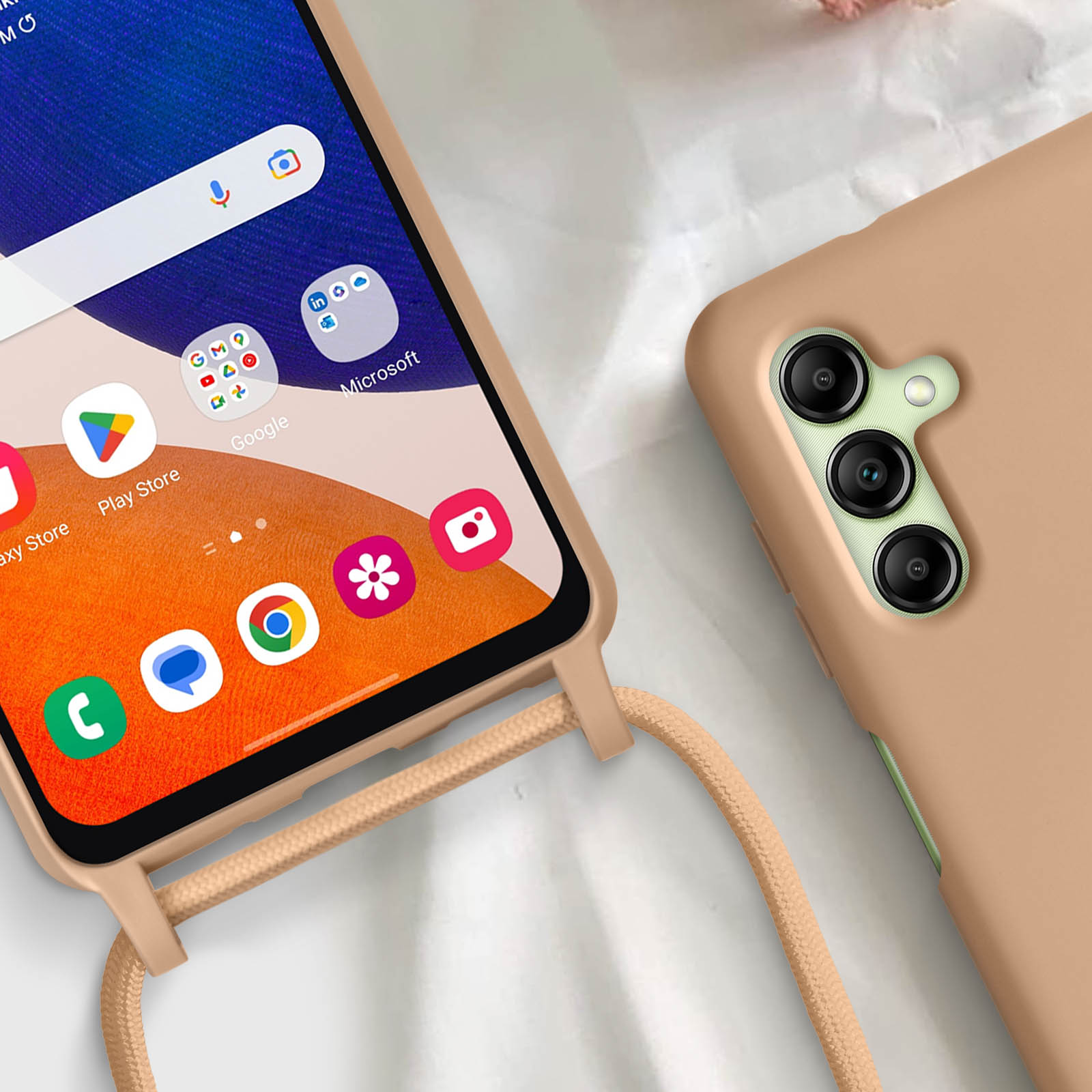 Un telefono con custodia e cordino, appoggiato su una superficie. Il telefono mostra le icone delle app. La custodia è beige.
