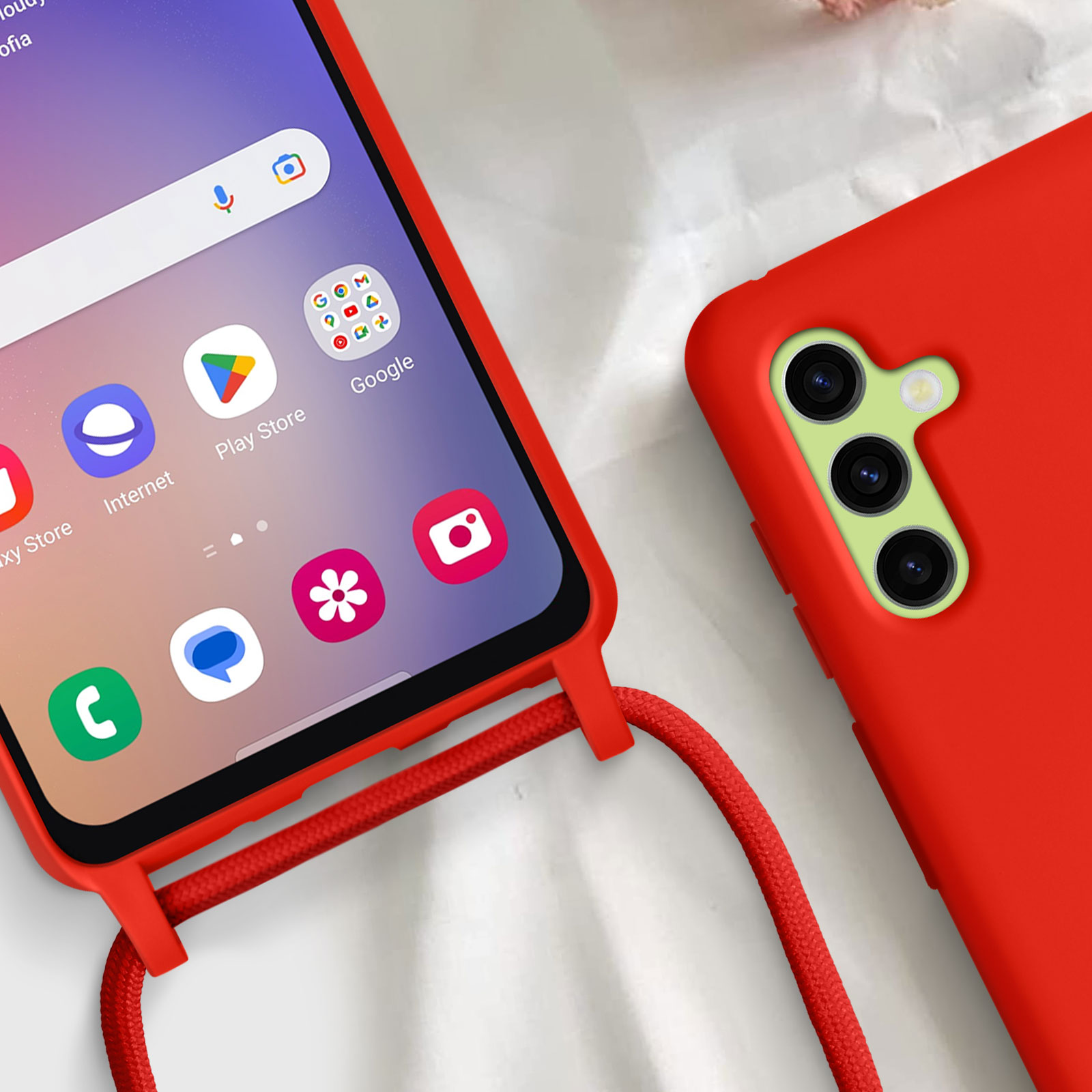Custodia rossa con cordino rosso, schermo del telefono con app. Un'altra custodia sullo sfondo.