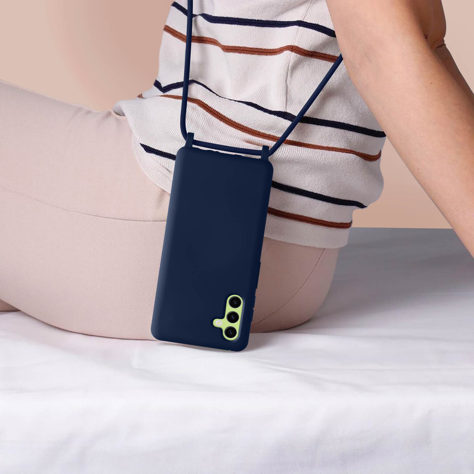 Une coque de téléphone bleu marine avec une lanière, portée par une personne.