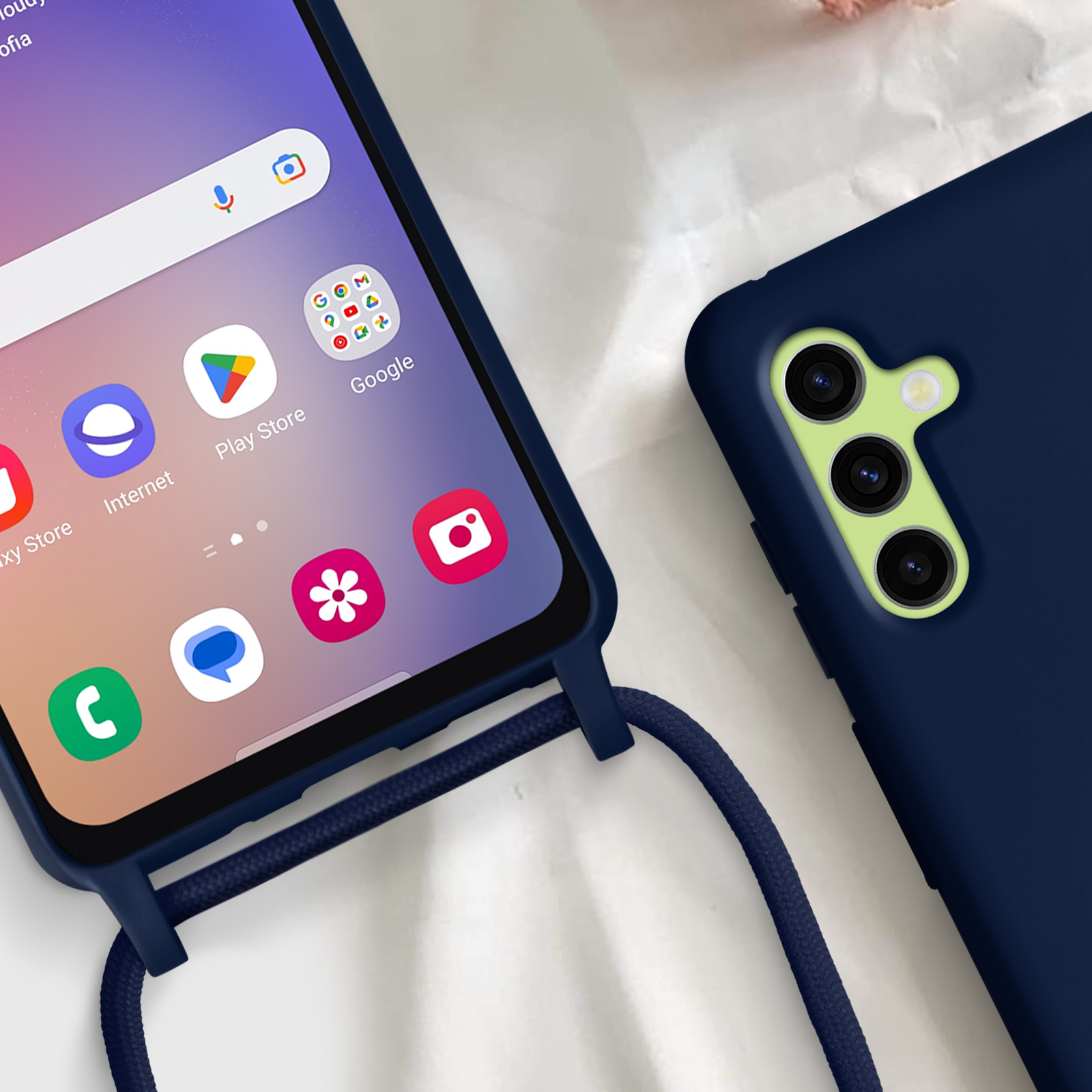 Un téléphone avec un étui bleu et un cordon. L'écran affiche des applications.