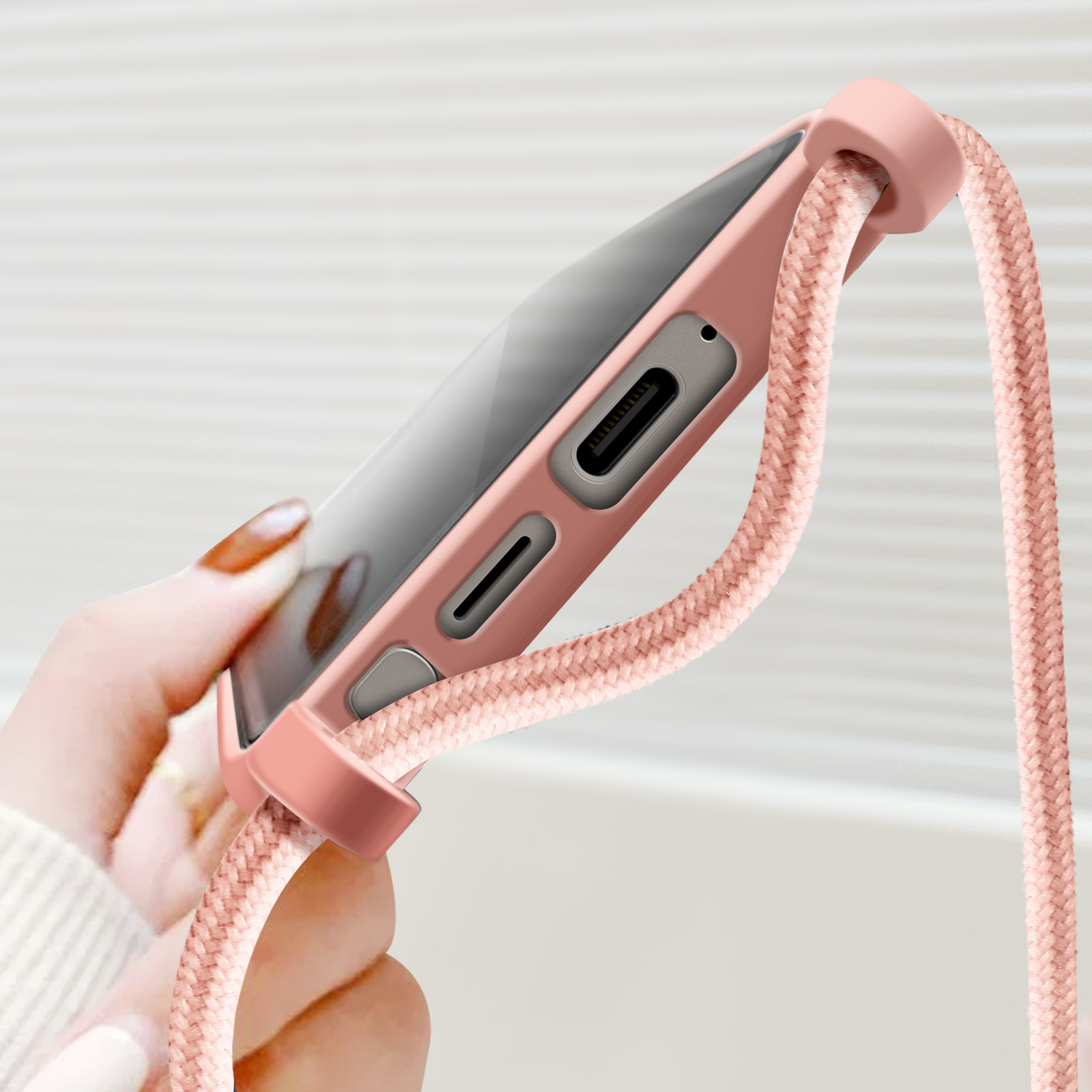 Custodia rosa per telefono con telefono e corda rosa. Il telefono è nella custodia.