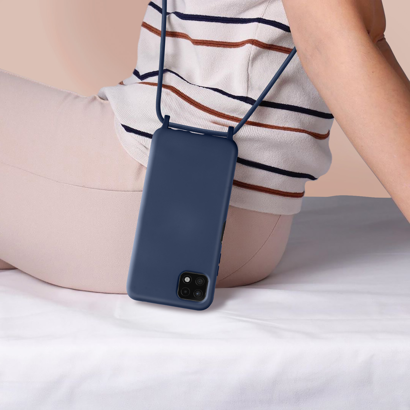 Coque de téléphone bleu marine avec cordon autour du cou d'une femme. Elle porte une chemise rayée.