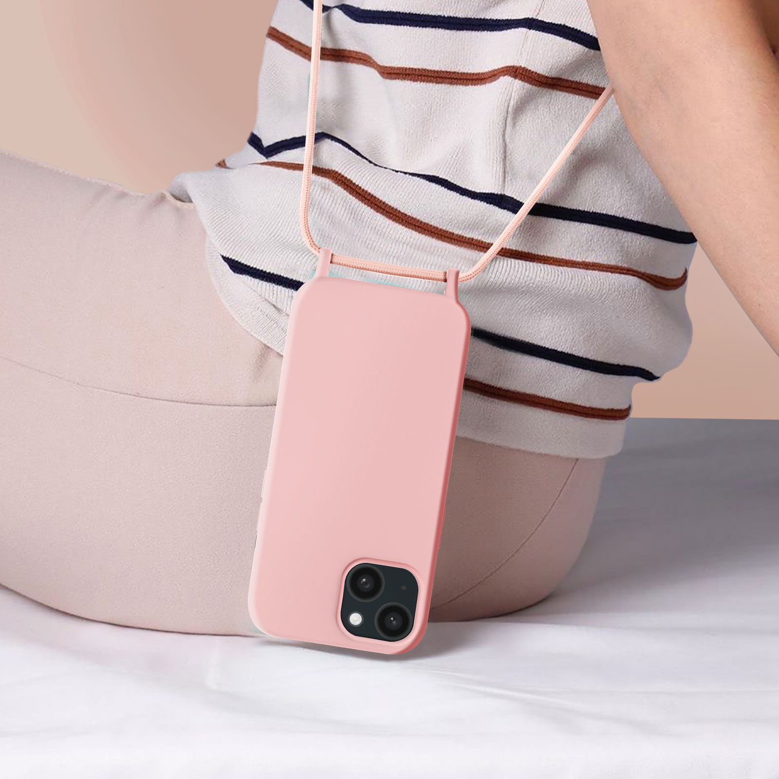 Una donna che indossa una custodia per telefono rosa con un cordino rosa.