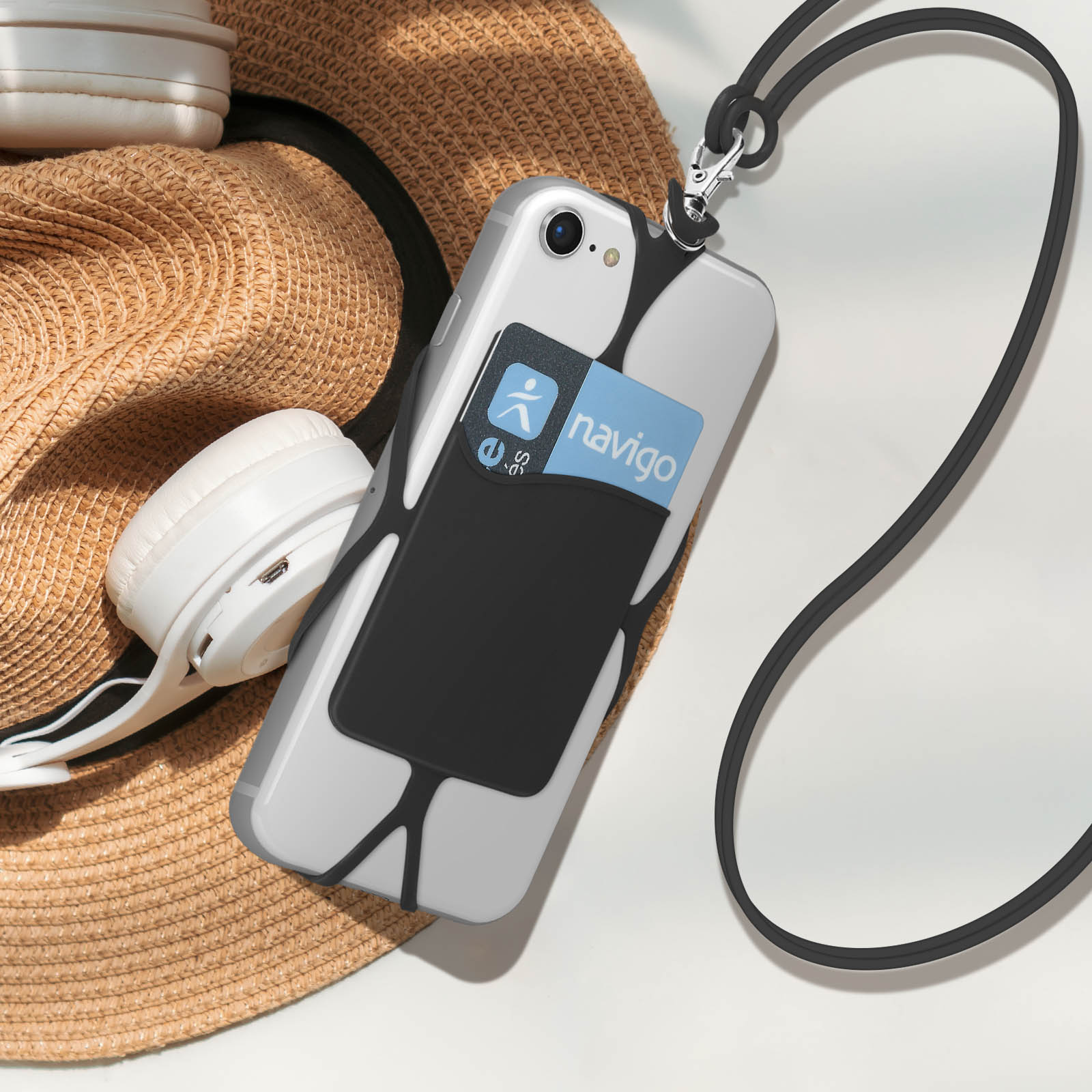 Telefono con custodia con portafoglio. Su un tavolo con cappello e cuffie.