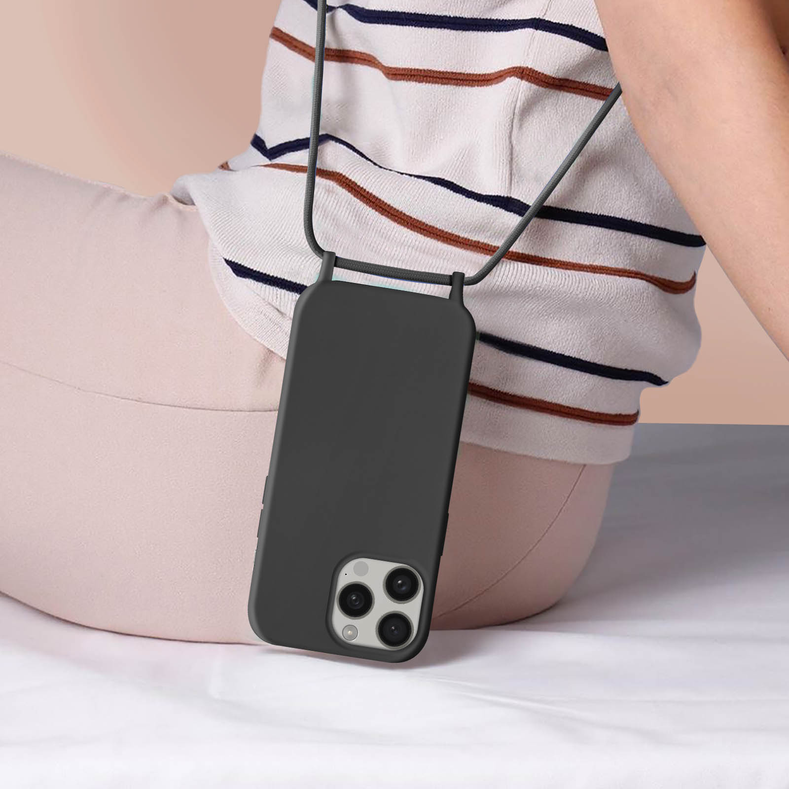 Telefono con custodia e cordino. Mostra le app. Lo sfondo è un tavolo.