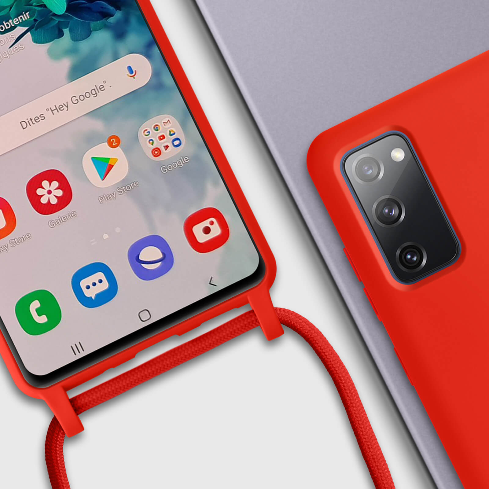 Coque de téléphone rouge avec une sangle rouge. L'écran du téléphone affiche les applications Google. Téléphone gris en arrière-plan.