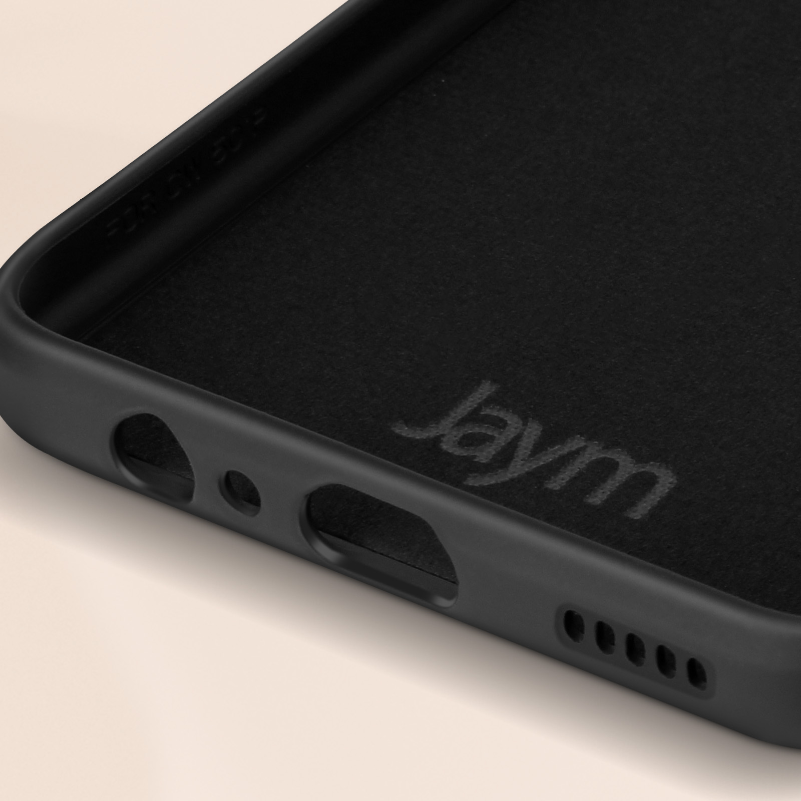 Nahaufnahme der Innenseite einer schwarzen Handyhülle mit dem Aufdruck "Jaym" in der Mitte.