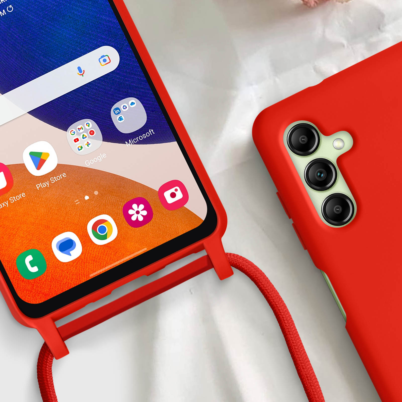 Primo piano di custodia rossa con cordino rosso accanto a telefono con icone.