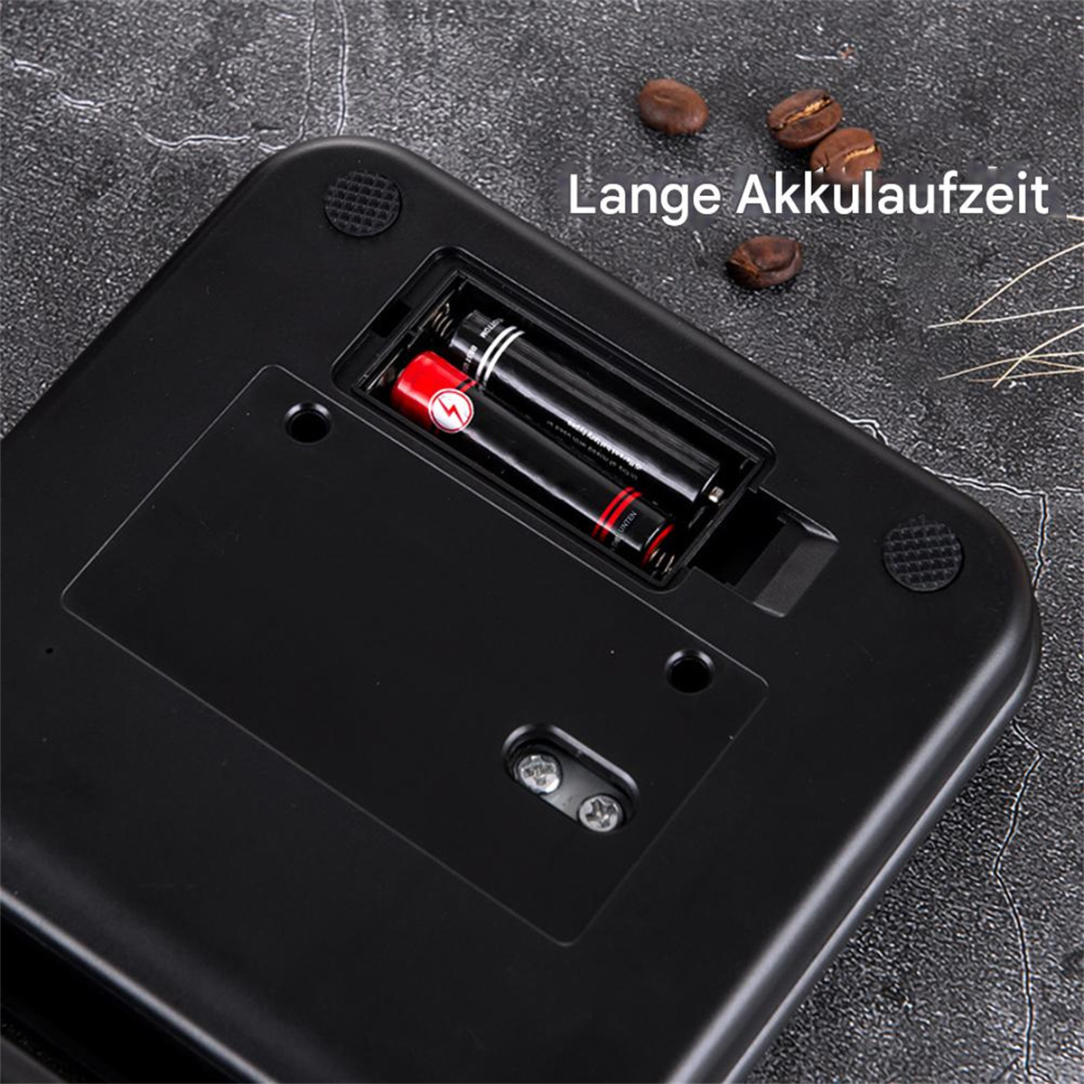 Schwarze Waage mit offenem Batteriefach, zeigt Batterien und Text.