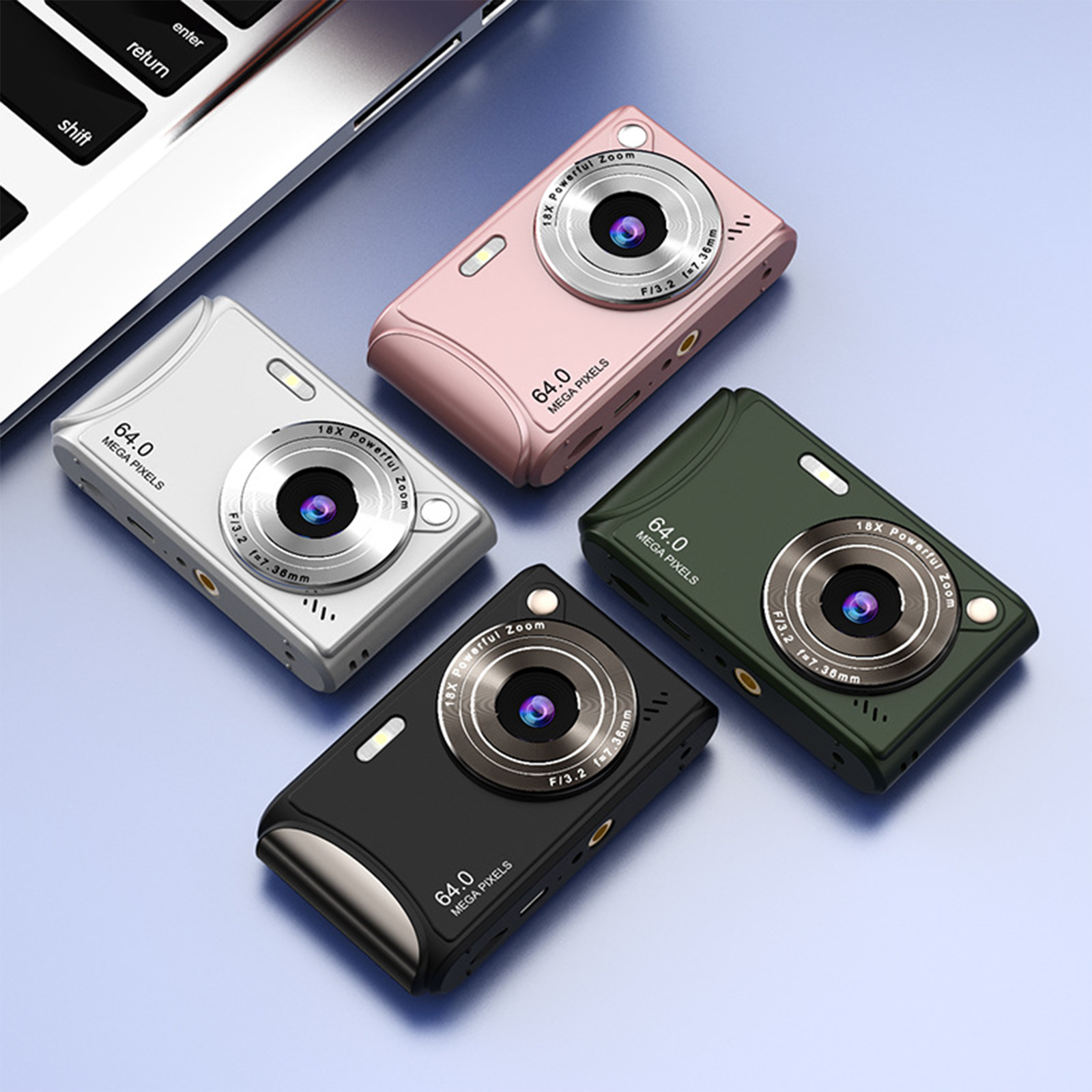 Vier kleine Digitalkameras in verschiedenen Farben: Silber, Rosa, Grün und Schwarz. Sie liegen auf einer Oberfläche.