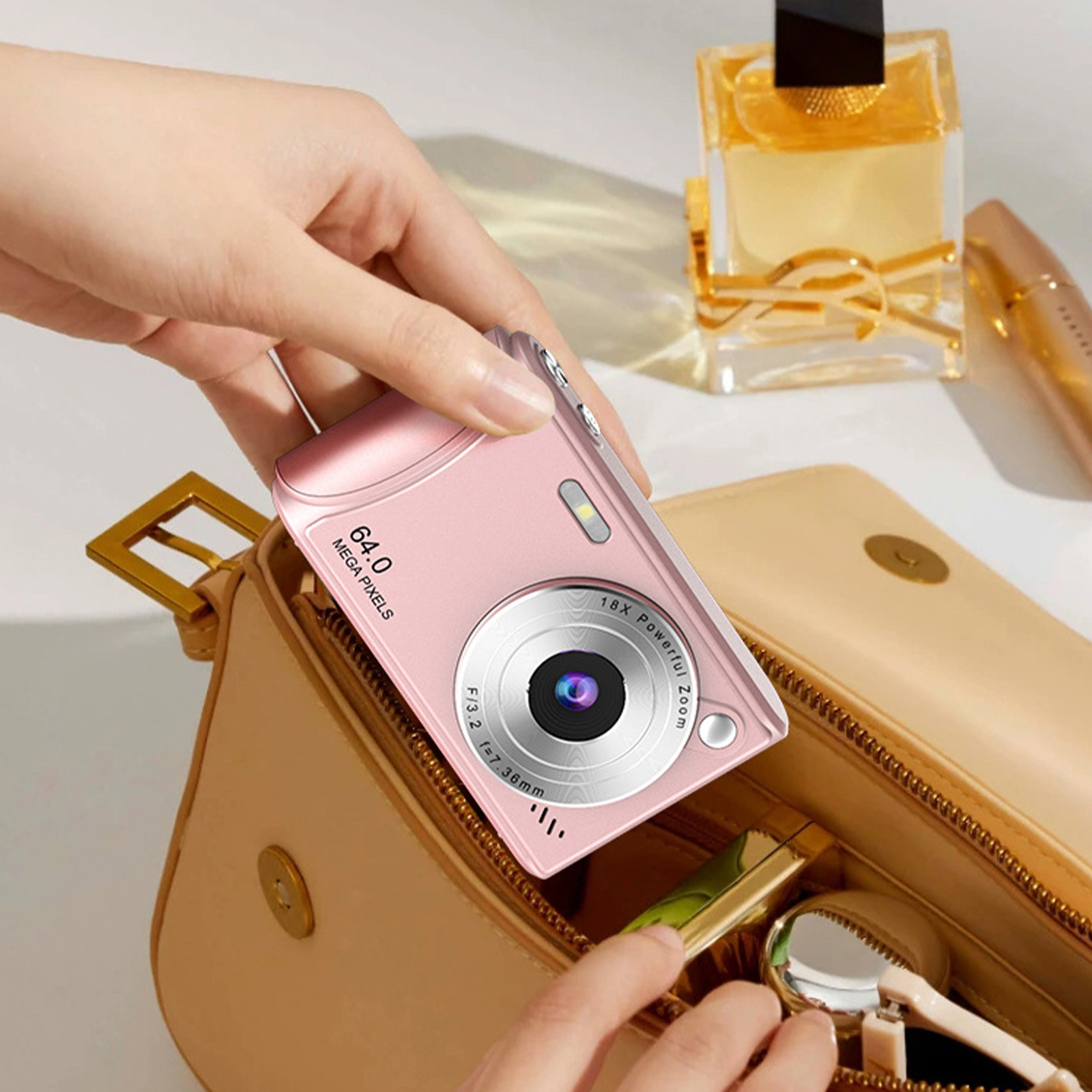 Rosa Kamera in einer Hand, teilweise aus einer Handtasche, mit Kosmetika im Hintergrund.