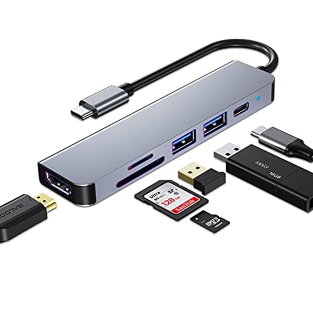 Silberner USB-Hub mit mehreren Anschlüssen, einschließlich HDMI, SD-Karte und USB, mit Zubehör.
