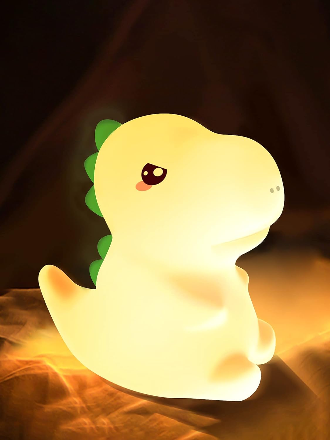 Gelbes Dinosaurier-Nachtlicht, das in einem dunklen Raum leuchtet, mit einem grünen Rückgrat.