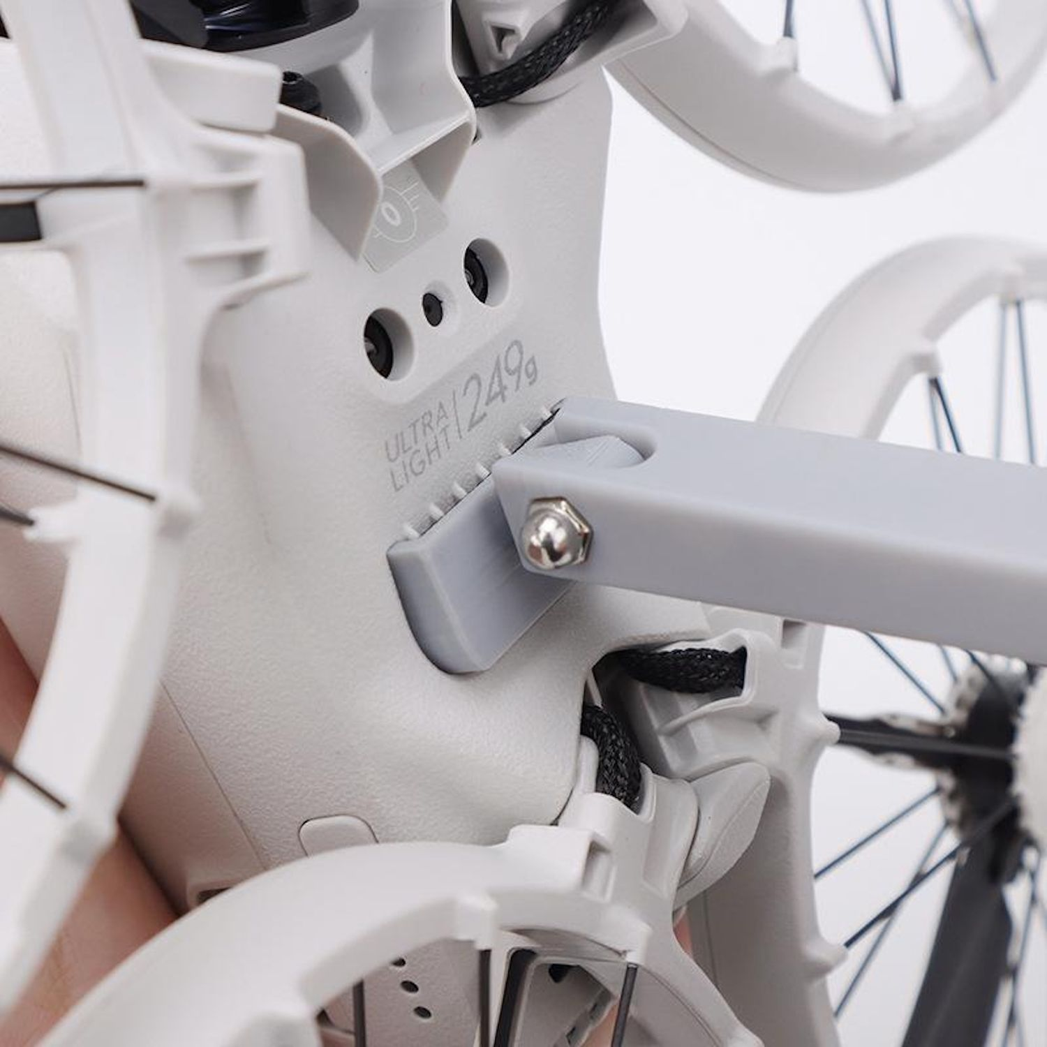 Primo piano di un telaio di drone bianco con braccio grigio e supporto dell'elica. Testo 'ULTRA LIGHT 249g'.