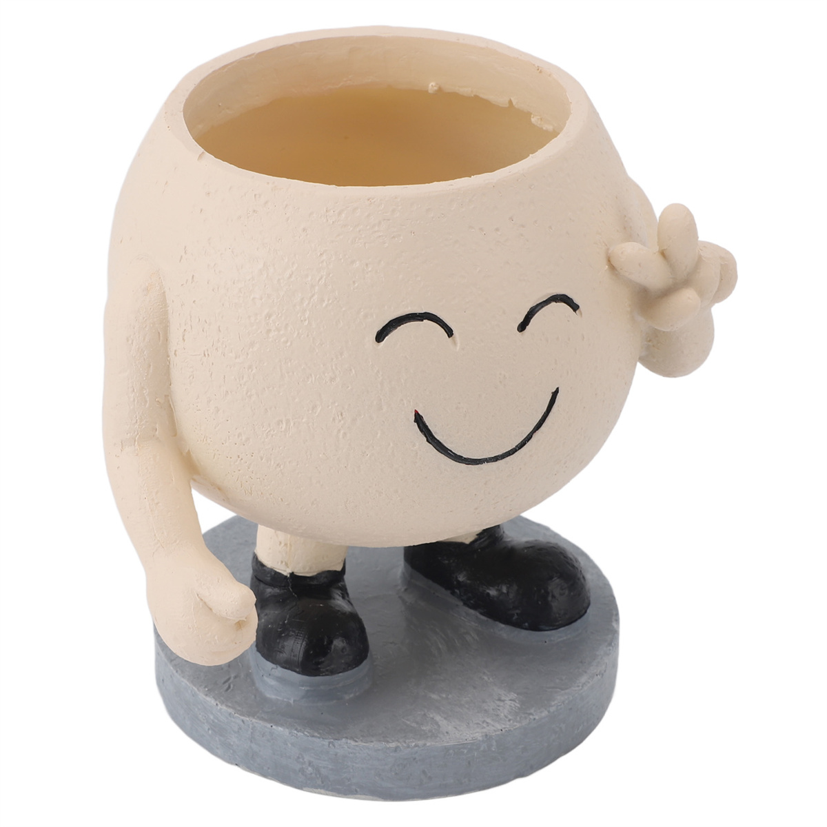 Eine kleine, lächelnde, cremefarbene Figur, die ein Friedenszeichen gibt, auf einem grauen Sockel stehend.