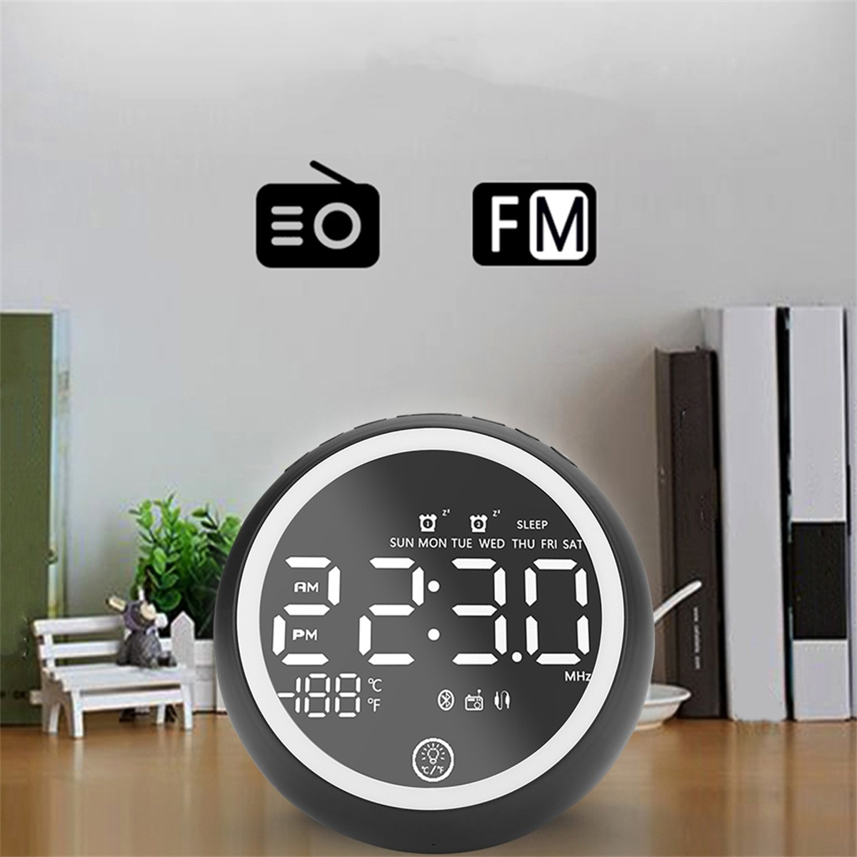 Schwarzer digitaler Wecker. Zeigt Uhrzeit, Datum, Temperatur und Funksymbole an. Hat ein FM-Radio-Logo.