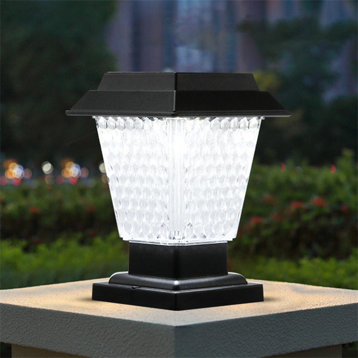Solar-Außenleuchte. Schwarzer Aufsatz und Sockel mit klarem, strukturiertem Licht. Die Lampe steht auf Stein.