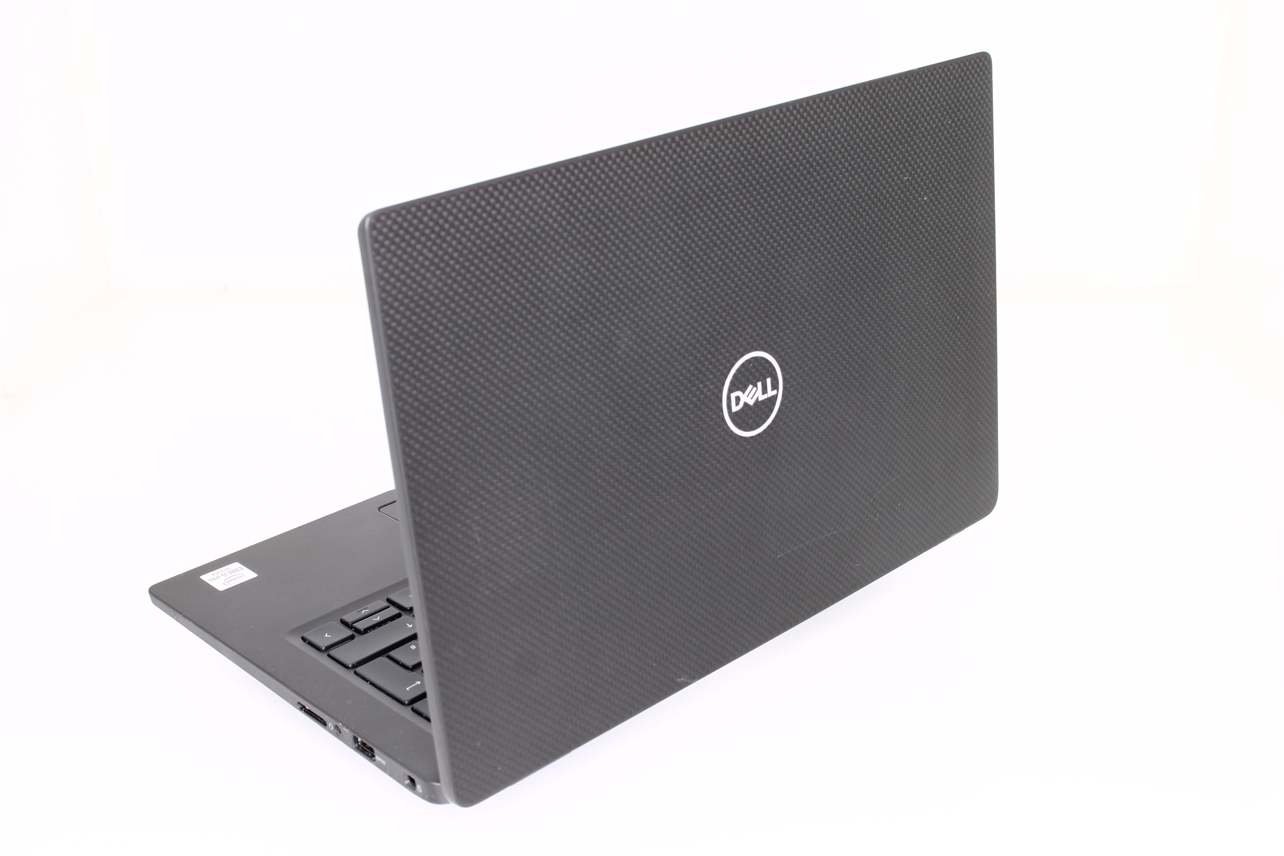 Laptop mit Dell-Logo auf weißer Oberfläche, schräge Ansicht.