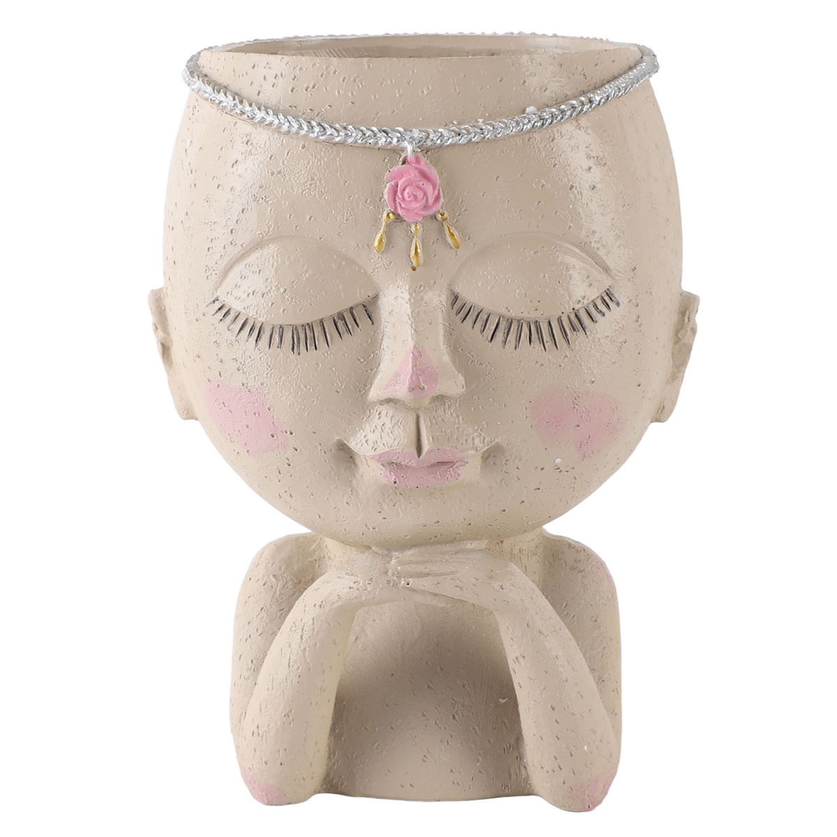 Beigefarbener kopfähnlicher Topf mit geschlossenen Augen, rosa Wangen und einem floralen Anhänger. Ein silbernes Band um den Kopf.