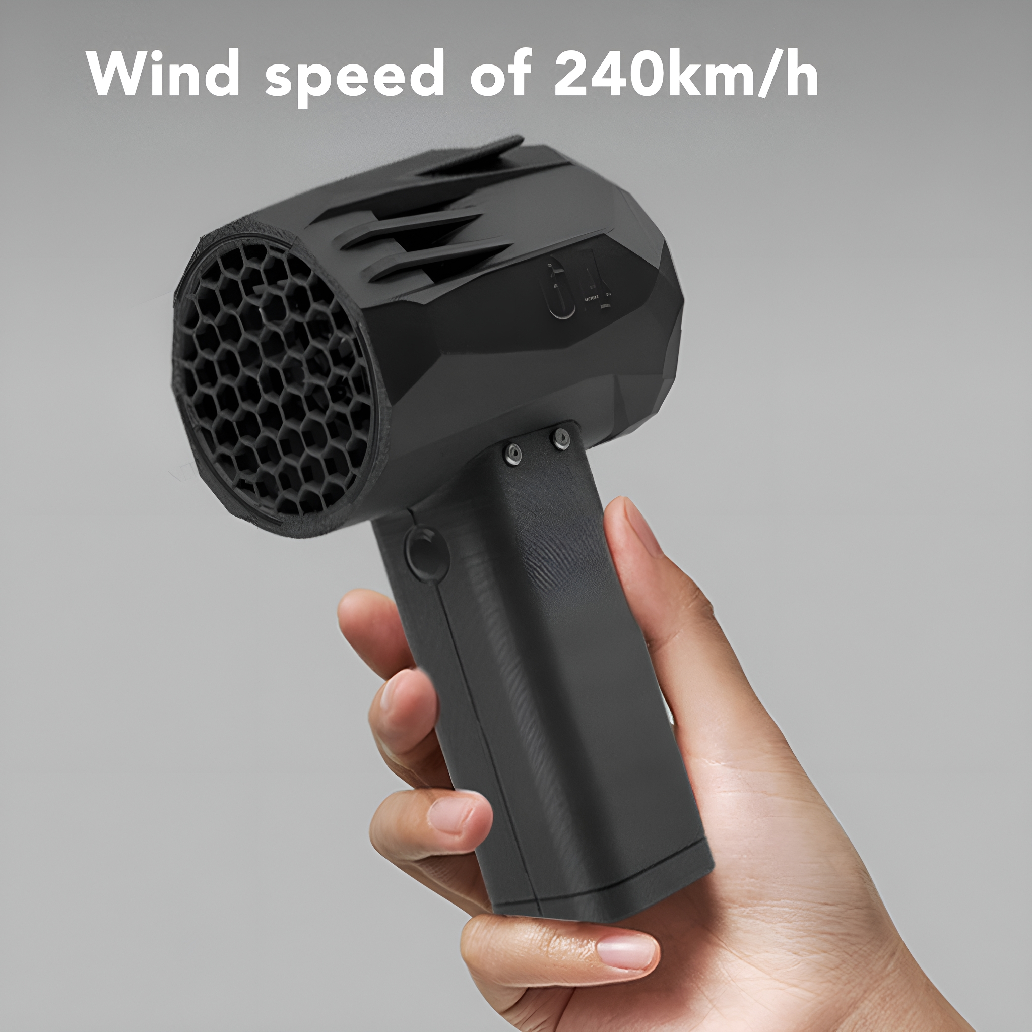 Schwarzes Gerät, gehalten von einer Hand, mit Wabenmuster vorne. 'Windgeschwindigkeit von 240 km/h'.