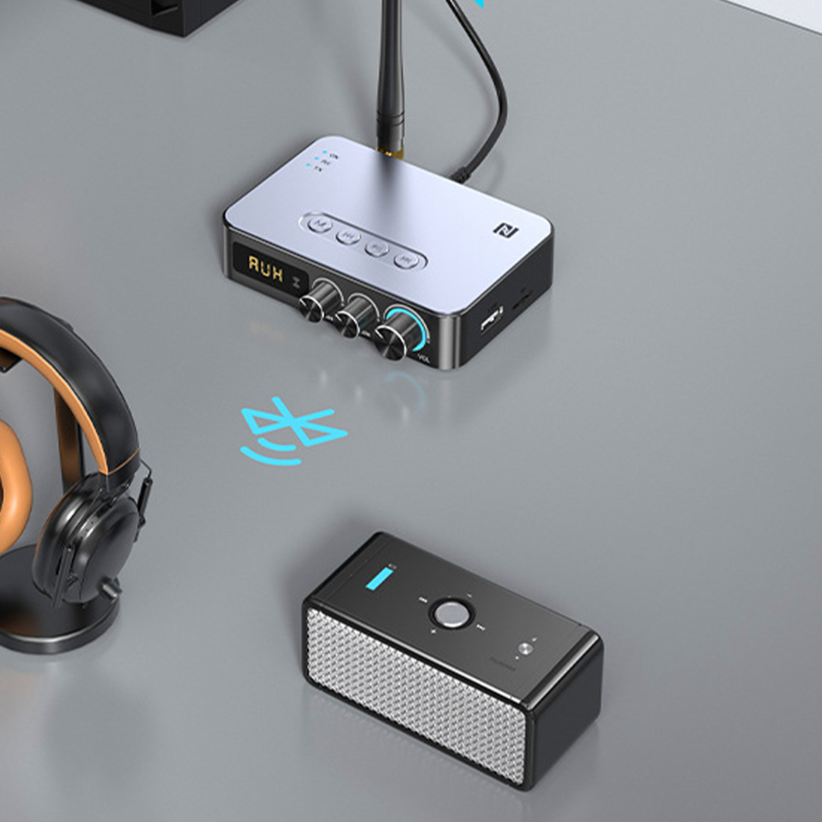 Elektronisches Audiogerät und Lautsprecher mit Smartphone auf grauer Oberfläche.