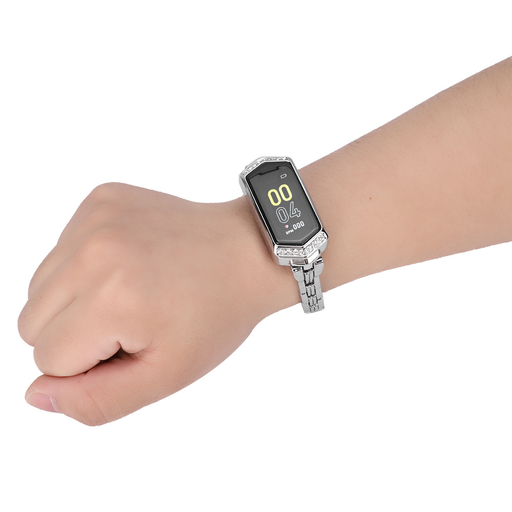 Das Handgelenk einer Frau mit einer silbernen Smartwatch. Die Uhr hat einen rechteckigen Bildschirm und ein silbernes Band.