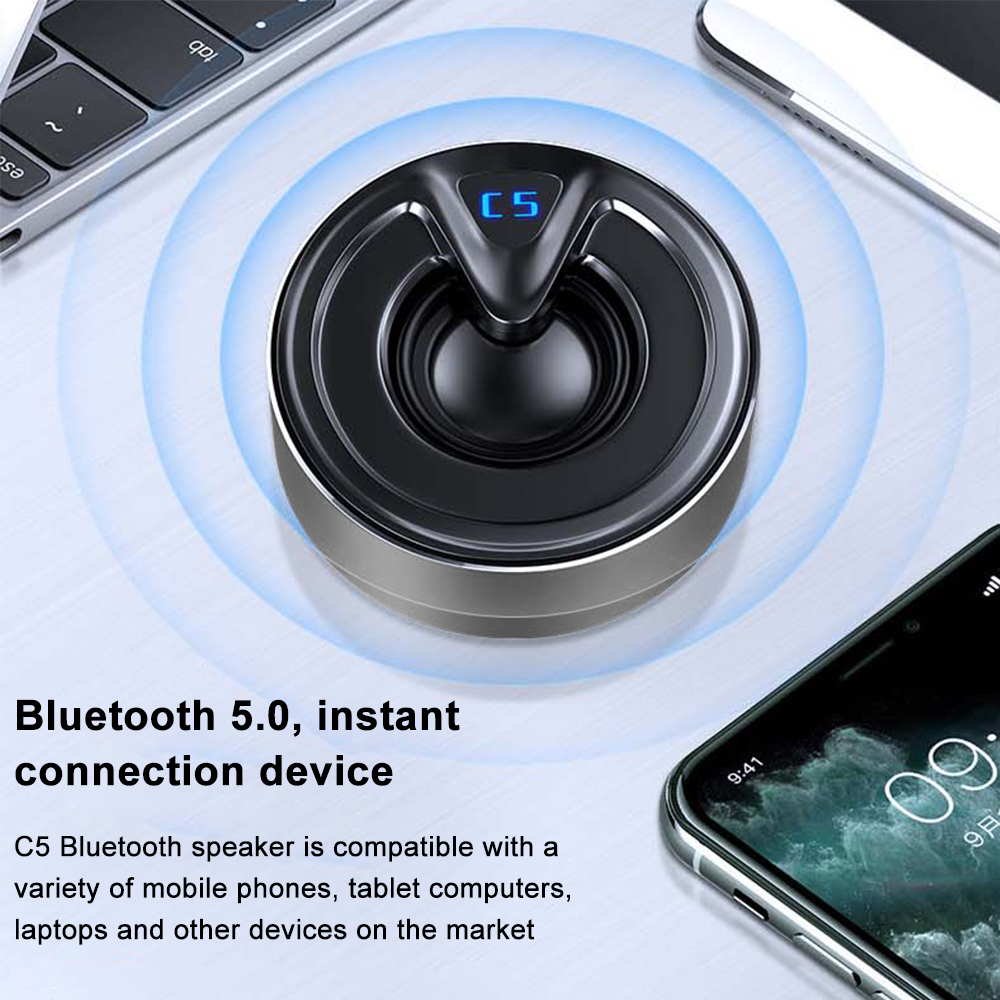 Ein schwarzer und silberner Bluetooth-Lautsprecher auf einem weißen Schreibtisch mit einem Telefon. Bluetooth-Symbol wird gezeigt.