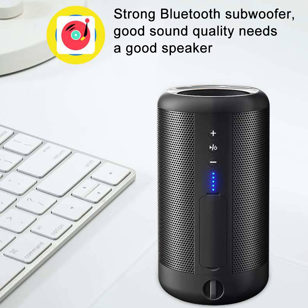 Schwarzer Bluetooth-Lautsprecher mit Bedientasten auf weißer Oberfläche, neben einer Tastatur.