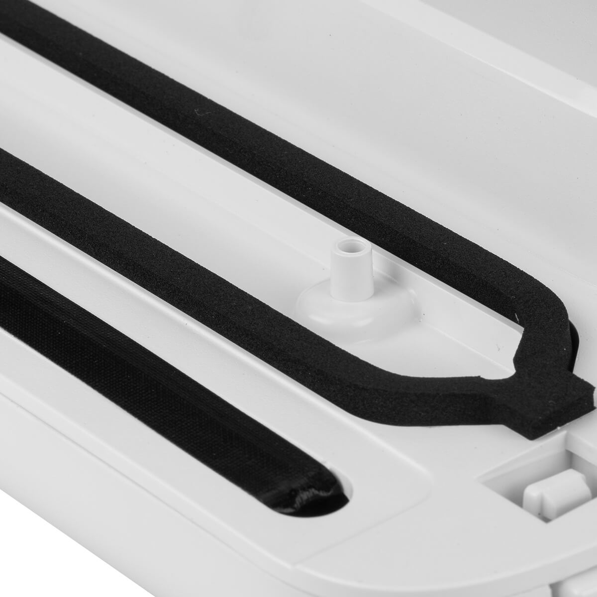 Zbliżenie na wnętrze białej zgrzewarki próżniowej.