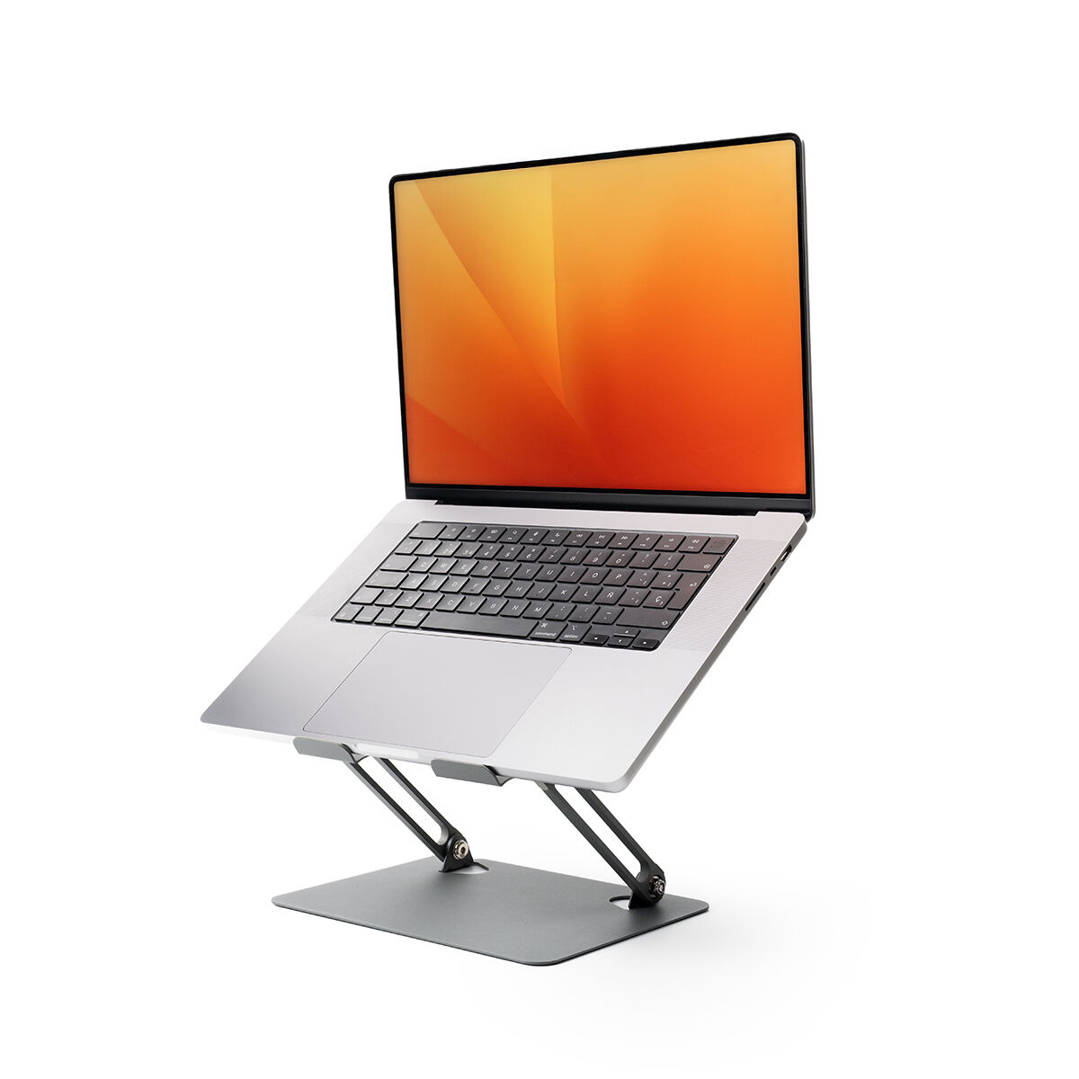 Laptop argentato su un supporto con sfondo arancione sullo schermo.