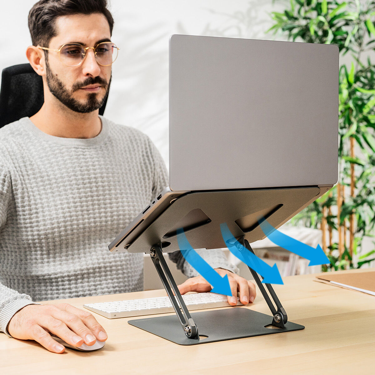 Un uomo con un laptop su un supporto, usa un mouse, con frecce che indicano il flusso d'aria.